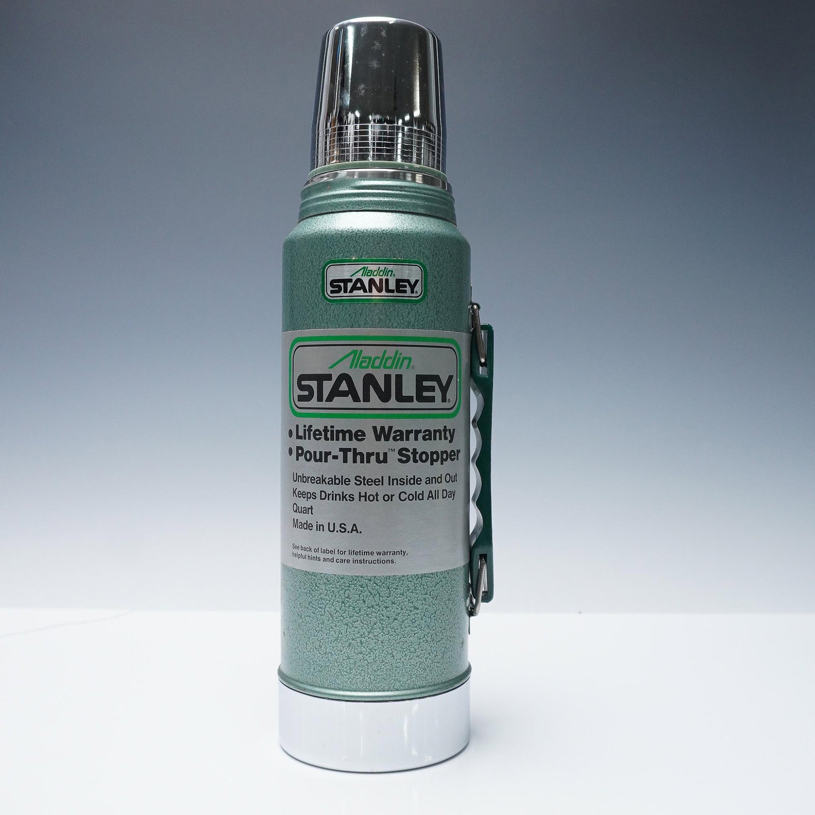 Stanley Aladdin Steel Quart Thermos with Original Box, 1985: Vintage Stanley Aladdin unbreakable steel thermos featuring the iconic green hammertone finish and original Pour-Thru stopper. Manufactured by Aladdin Industries in Nashville, TN, this American-made 1