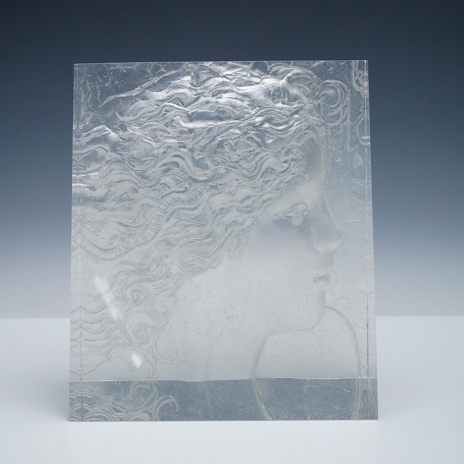 Frank Gallo Glass Sculpture, Woman's Profile Relief: Striking cast glass sculpture by American artist Frank Gallo (1933?2019), featuring a high-relief depiction of a woman's flowing profile in Gallo?s signature romantic style. The piece is signed Frank