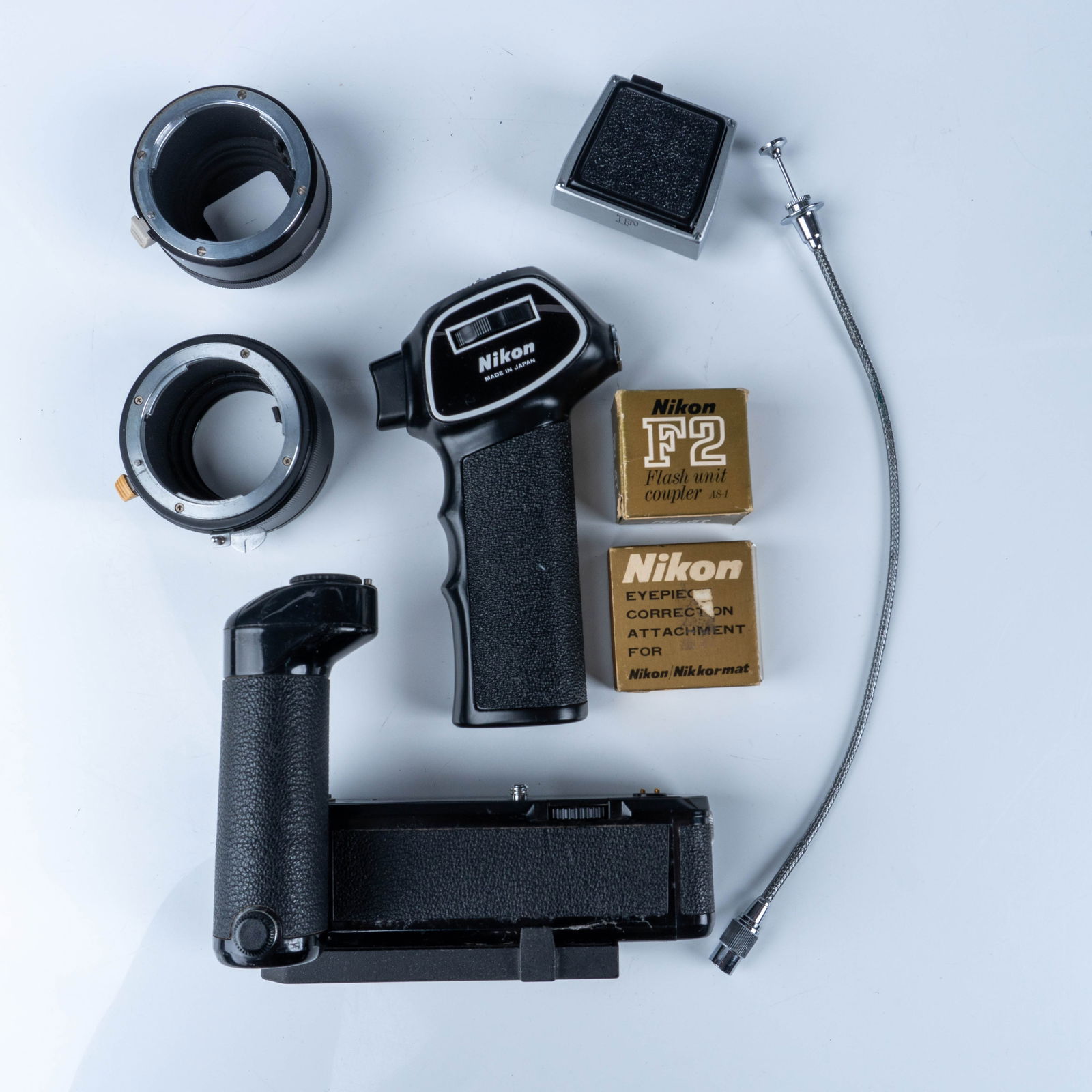 Vintage Nikon Accessories Set with Original Boxes: This auction features a collection of vintage Nikon camera accessories, showcasing the craftsmanship and innovation of Nikon, a leading Japanese optics company renowned for its exceptional camera equi