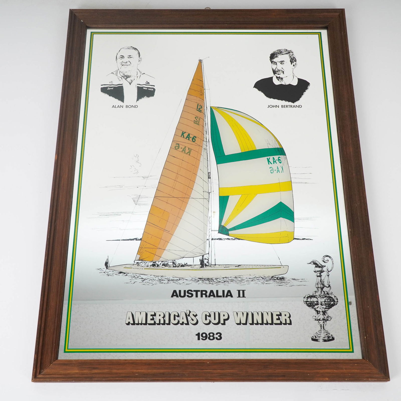 Australia II America's Cup Winner 1983 Framed Mirror by Seriprint: Framed commemorative mirror celebrating the historic 1983 America's Cup victory by Australia II, featuring vibrant imagery of the yacht KA-6 with its iconic winged keel and colorful sail. Portrait ill