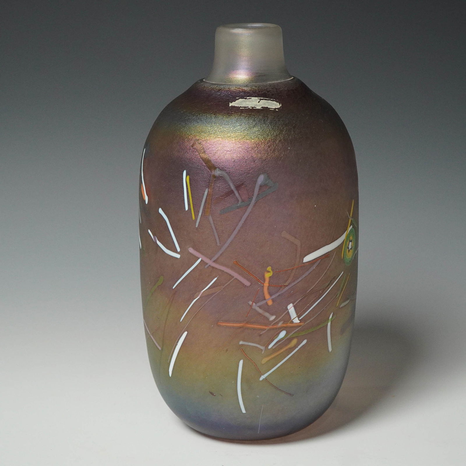 Bertil Vallien Art Glass Vase, Kosta Boda: Contemporary art glass vase by renowned Swedish artist Bertil Vallien for Kosta Boda. This iridescent bottle-form vase features embedded multicolored rods and abstract motifs throughout a satin-finish