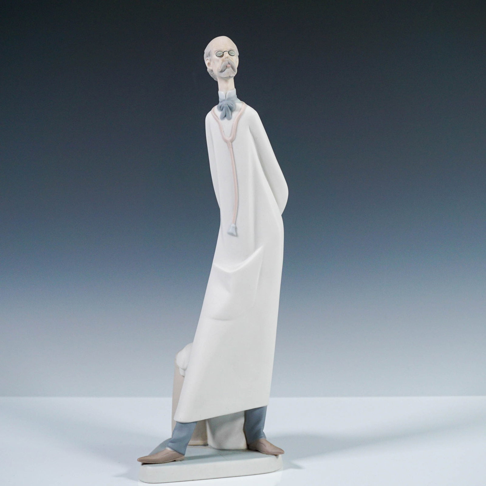 Lladro Porcelain Figurine, Doctor 1014602: Designed by Salvador Furió for Lladró, this figurine titled Doctor (item number 1014602) portrays a dignified physician in a long white coat, with arms clasped behind his back, and a stethoscope aro
