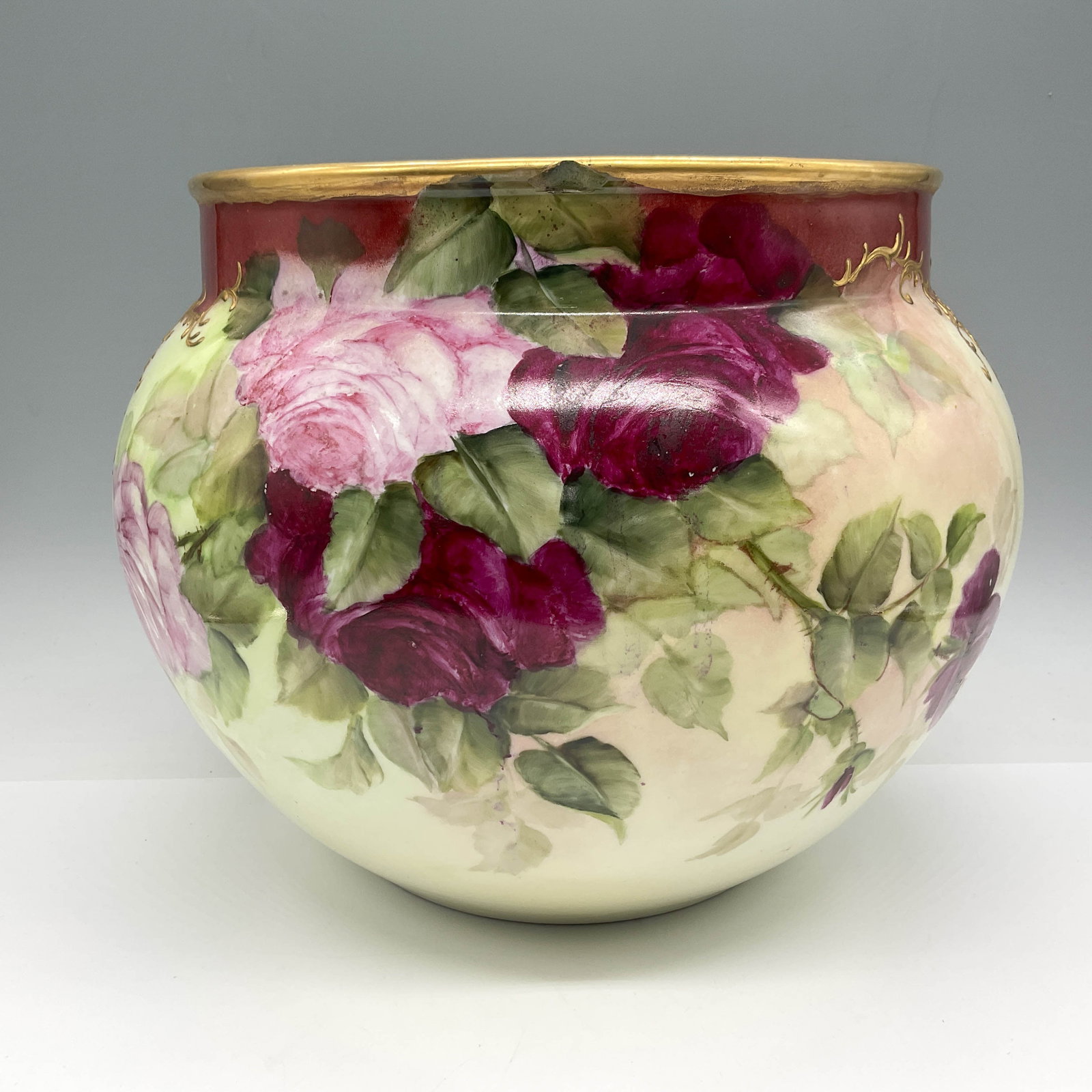 Jean Pouyat Limoges Porcelain Jardiniere: Lovely hand painted vessel designed with floral motif and gilt vine work. Coloration is a variety of green, peach, burnt sienna and burgundy. J.P. Limoges France backstamp. Artist: Duval Dimensions: 8