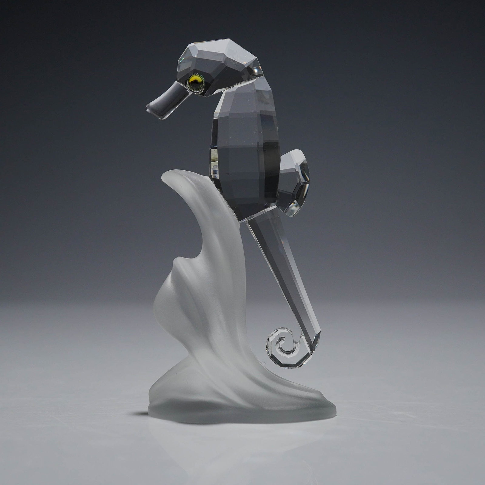 Swarovski Crystal Figurine, Sea Horse 168683: A Swarovski Silver Crystal figurine titled Sea Horse, item number 168683. This figurine features a clear faceted crystal body with black and yellow eyes, poised on a frosted wave-shaped base. Part of 