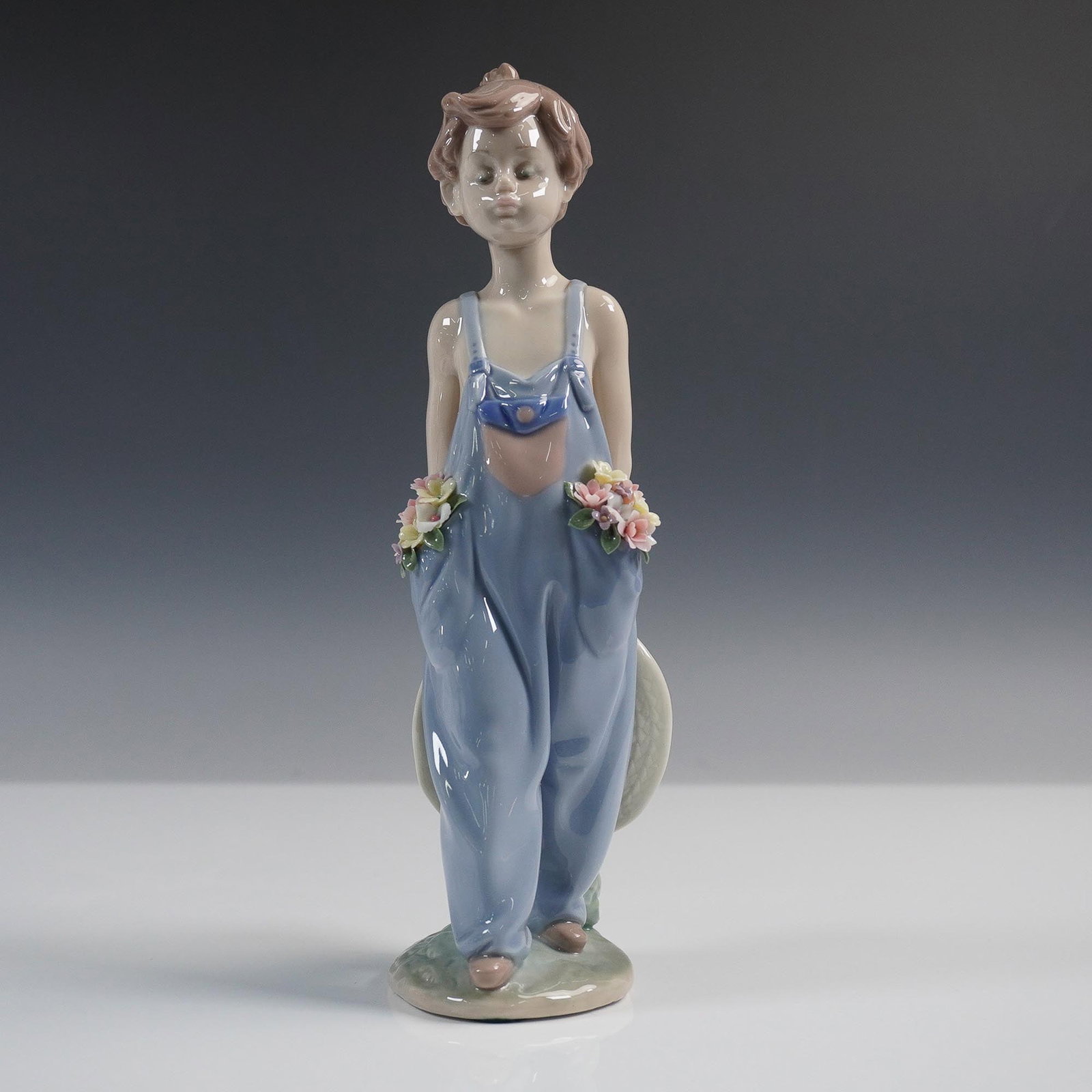 Lladro Porcelain Figurine, Pocket Full of Wishes 1007650: Lladro porcelain figurine titled Pocket Full of Wishes, model number 1007650. Sculpted by Antonio Ramos and issued in 1997 exclusively for the Lladro Collectors Society. The piece depicts a young boy 