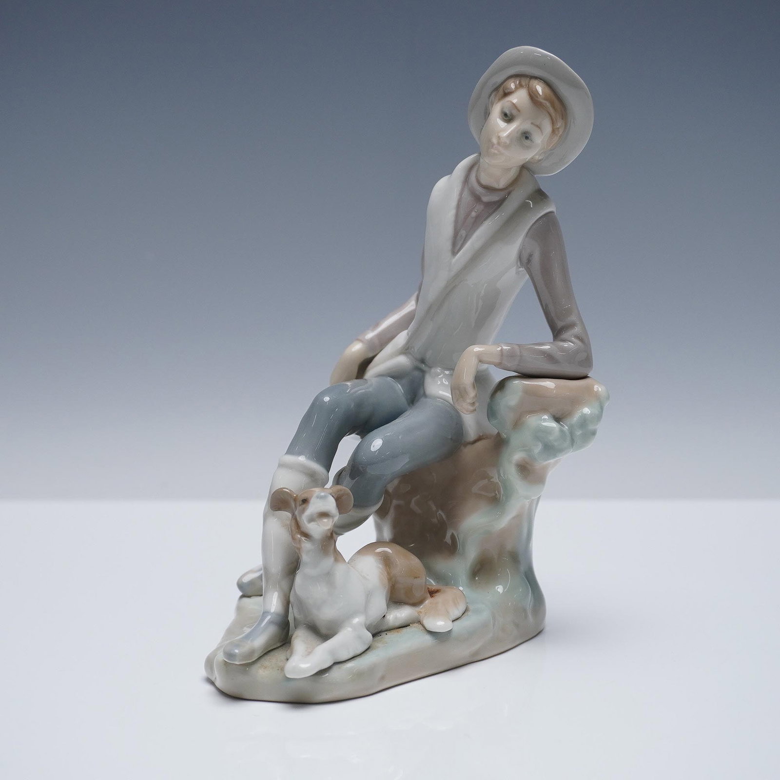 Lladro Porcelain Figurine, Shepherd 01004659: Lladro porcelain figurine titled Shepherd, model number 01004659. This graceful sculpture depicts a young shepherd standing with staff in hand, dressed in flowing robes and gazing downward in a contem