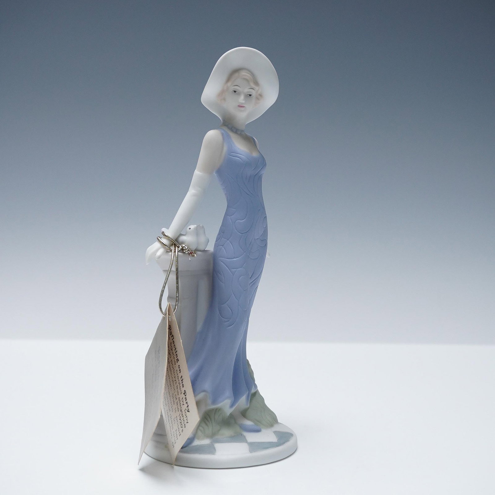 Tony Chango Porcelain Figurine, Reflecting on the Party: Elegant porcelain figurine titled Reflecting on the Party by artist Tony Chango, depicting a refined woman in a flowing blue gown and wide-brimmed hat leaning gently against a classical pedestal with 
