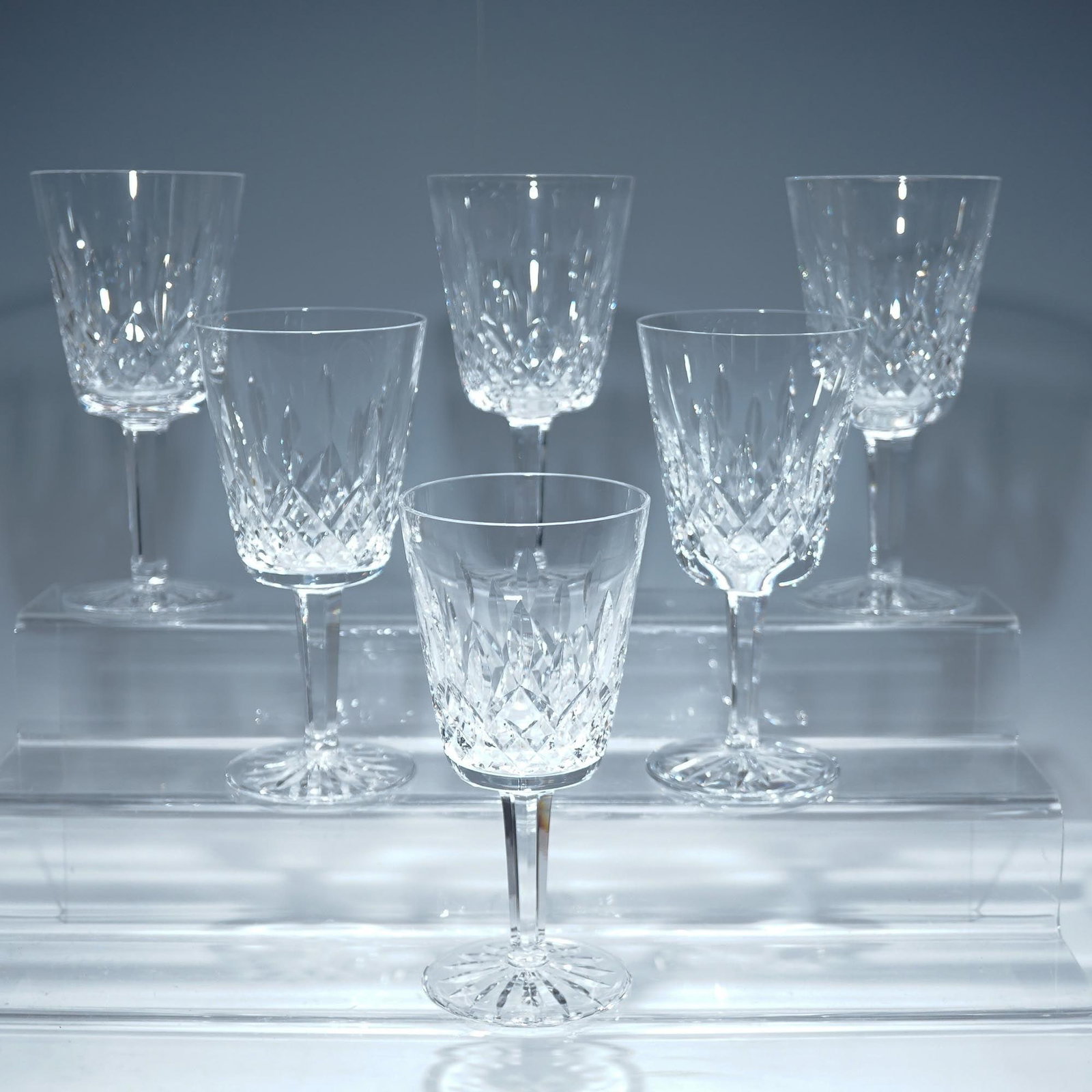 6pc Waterford Crystal Water Goblets, Lismore: Set of six fine Waterford crystal wine glasses in the iconic Lismore pattern, each exhibiting a brilliant combination of diamond and wedge cuts that reflect light with stunning clarity. Crafted in Ire
