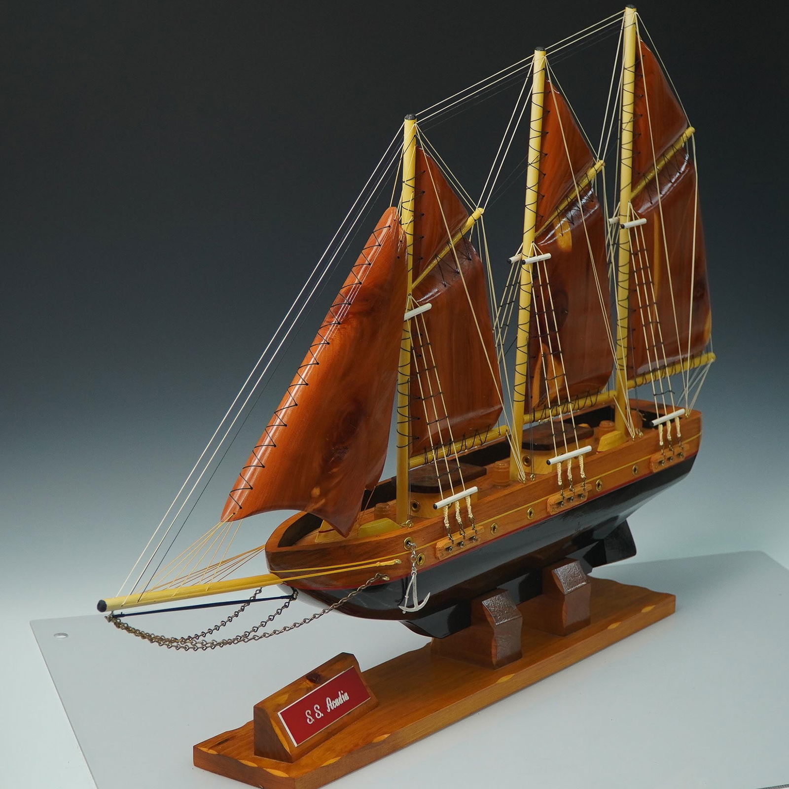 Wooden Model Ship, S.S. Acadia, 3-Masted Schooner: Detailed wooden model ship of the S.S. Acadia, a three-masted schooner-style vessel crafted with rich wood tones and rigging accents. Displayed on a wood base with a nameplate, this handcrafted model