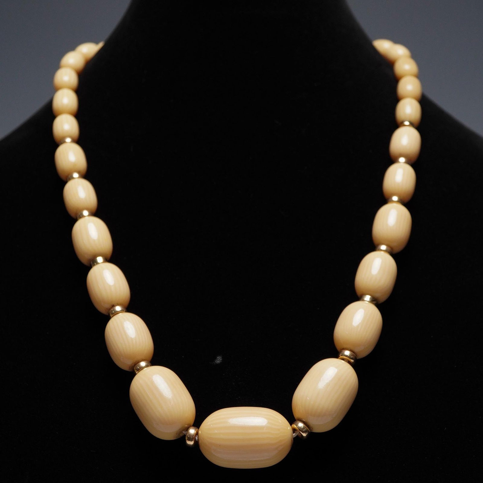 Vintage Celluloid Bead Necklace with 14K Spacers: This vintage necklace features a strand of cream-colored oval celluloid beads, strung continuously without a clasp for a seamless look. The beads are separated by small round spacers believed to be 14