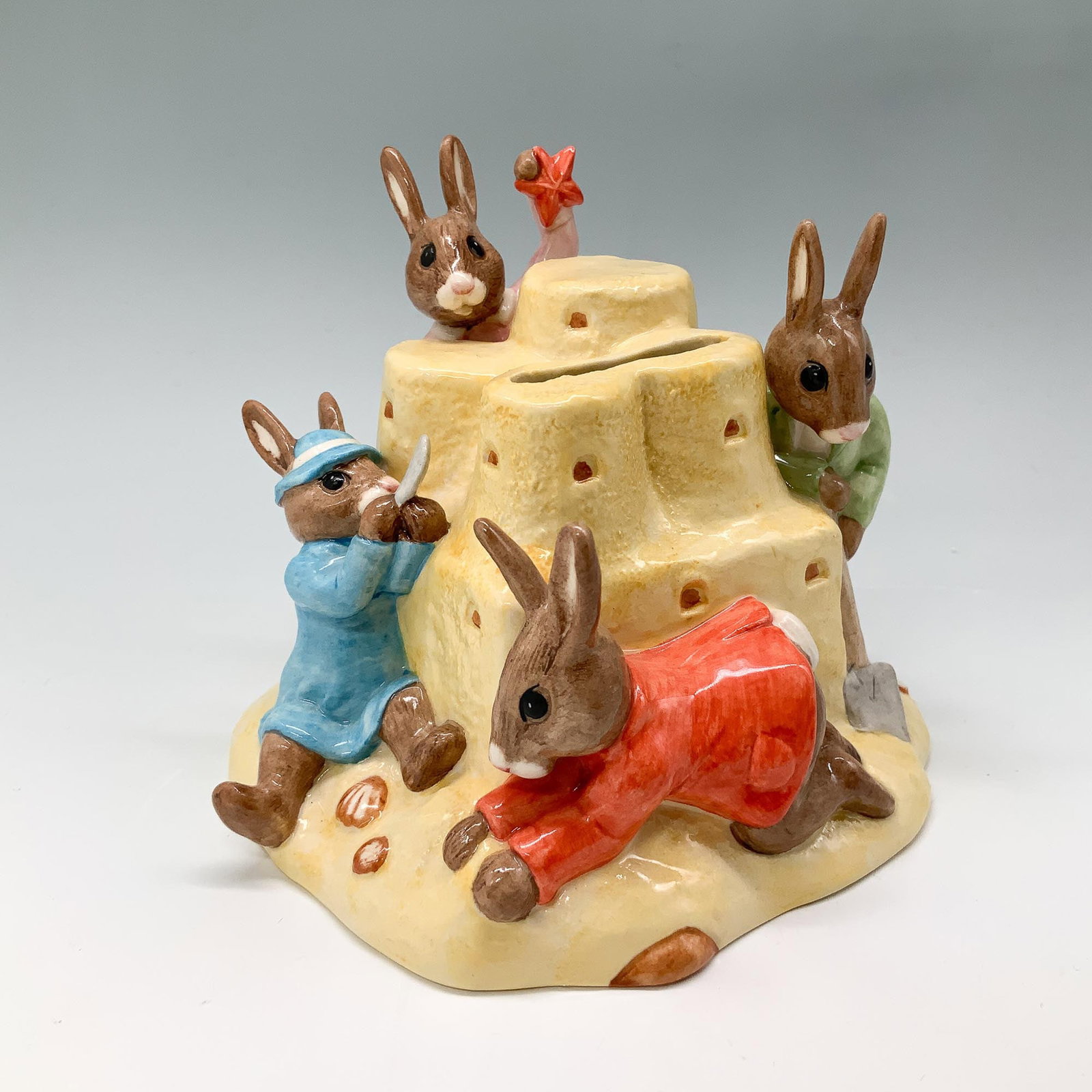 Sandcastle Money Box DB228 - Royal Doulton Bunnykins: This charming Royal Doulton Bunnykins Sandcastle Money Box figurine, DB 228, was hand-made and hand-decorated to commemorate the 30th anniversary of Bunnykins DB figures (1972-2002). The intricate des