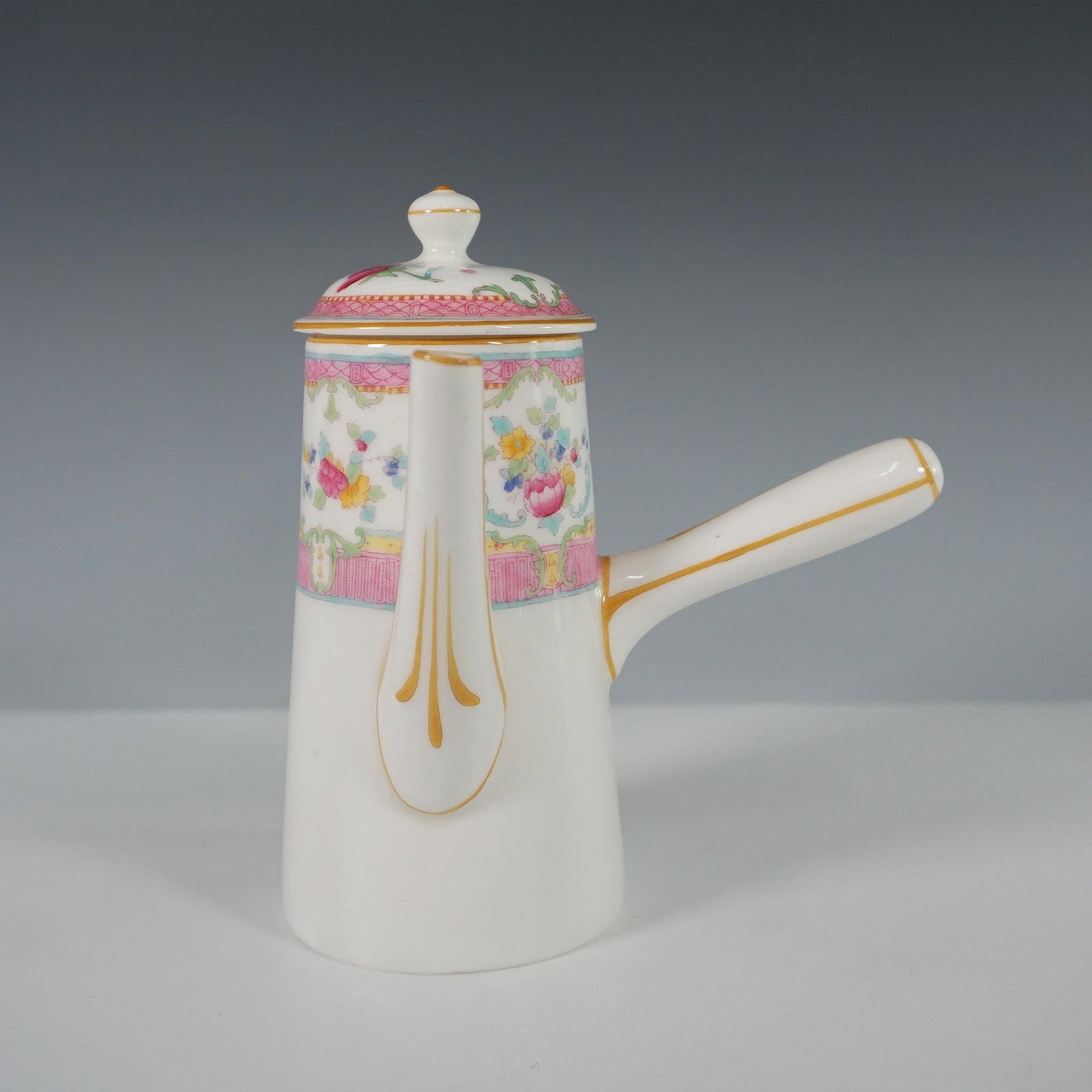 Royal Doulton Porcelain Chocolate Pot with Floral Motif: Elegant Royal Doulton porcelain chocolate pot featuring a delicate floral design with pastel hues of pink, green, and yellow accented with gold trim. The upper portion showcases a detailed decorative 