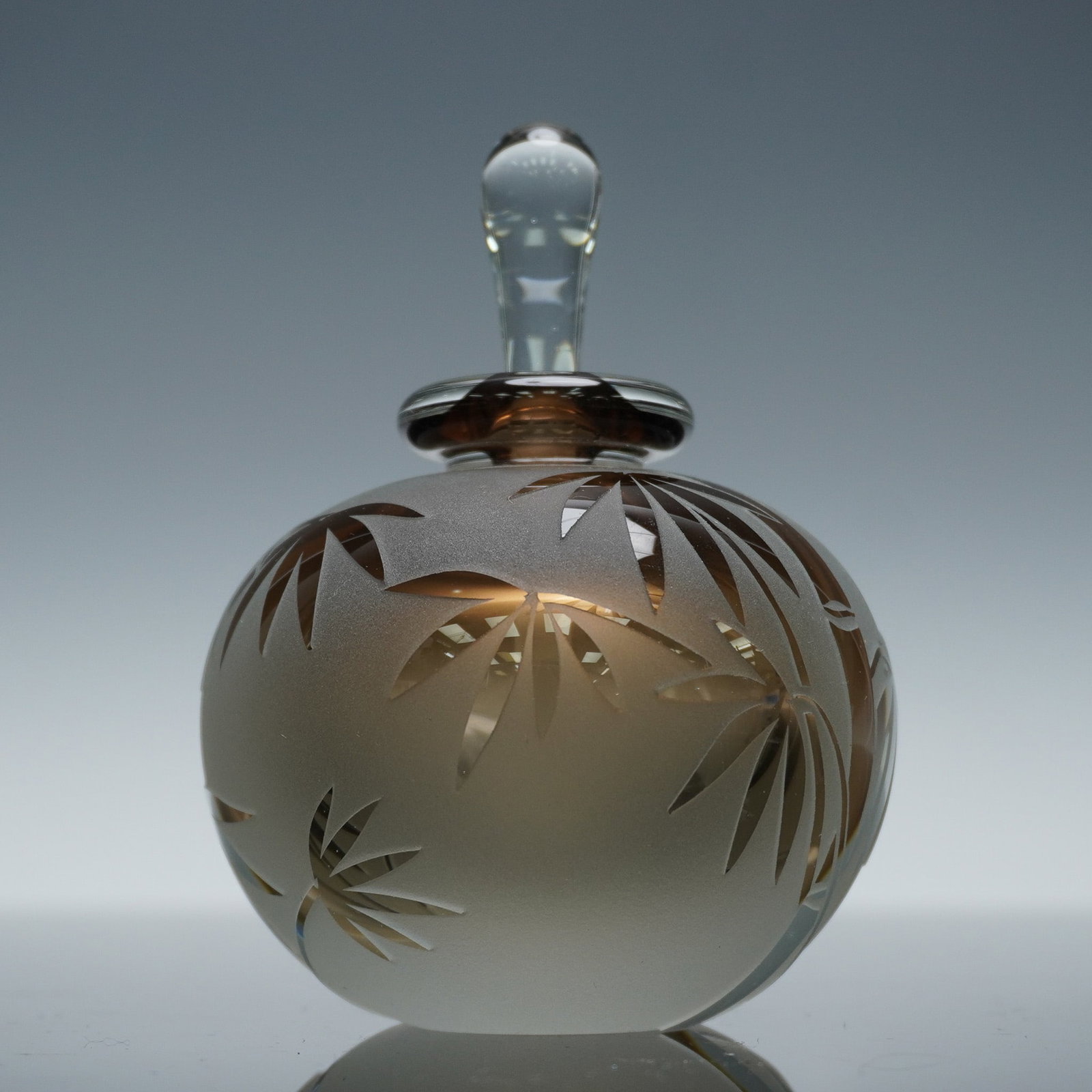 K W Le Duier Art Glass Perfume Bottle with Stopper, Signed: This art glass perfume bottle showcases a captivating amber to clear gradient finish with a satin etched surface and stylized leaf cutwork. The bulbous body is topped with a matching glass stopper and