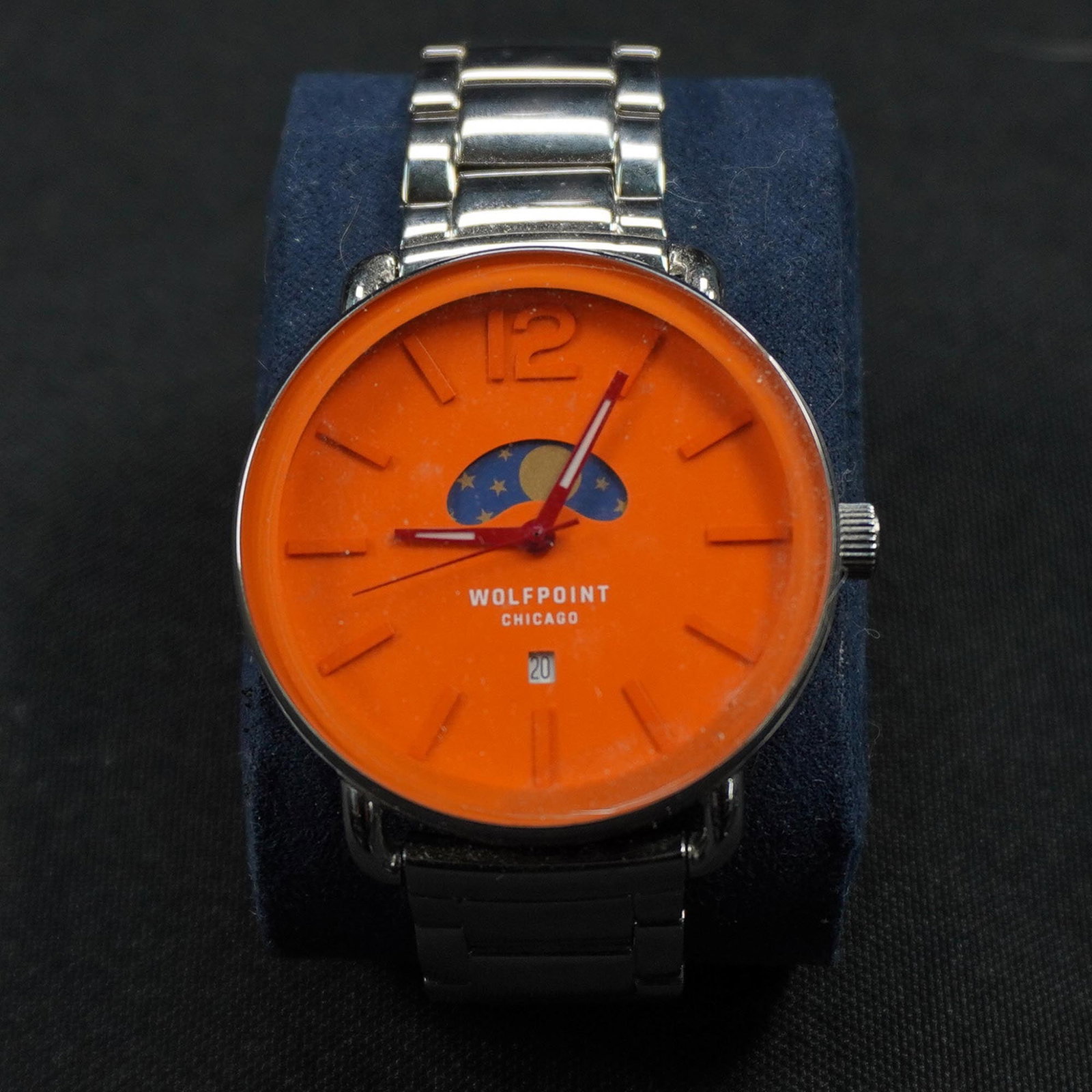Wolfpoint Chicago Wristwatch with Orange Dial and Moonphase Display: Wolfpoint Chicago wristwatch featuring a bold orange dial accented by a moonphase-style display beneath the 12 o'clock marker. The watch includes minimalist hour markers, a raised numeral "12," and a 