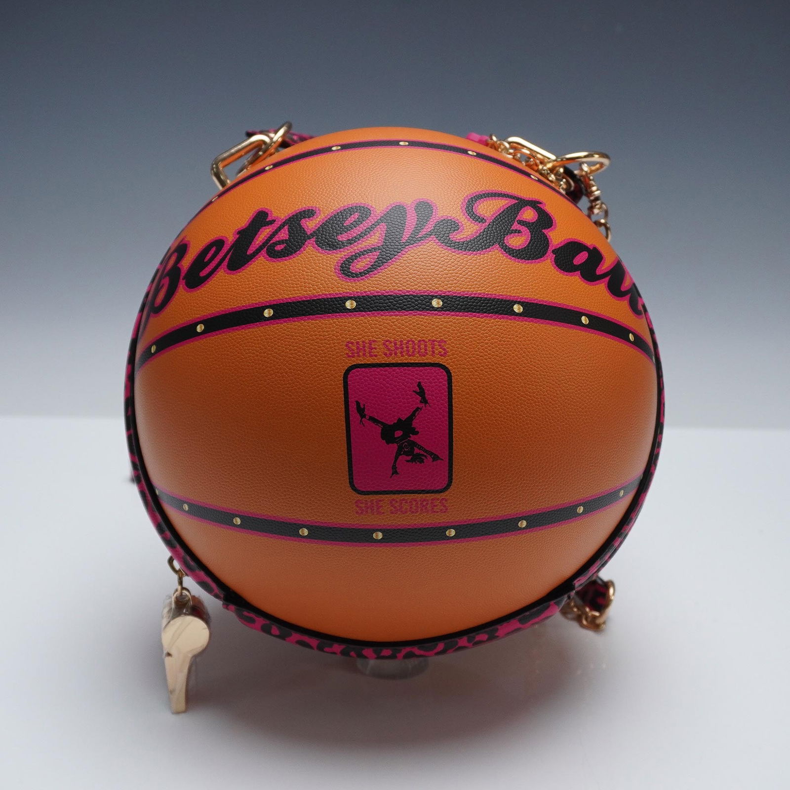 Betsey Johnson Pink Leopard Basketball Purse: Whimsical and sporty, this Betsey Johnson basketball-shaped purse features pink and black leopard-print trim, gold-tone hardware, and bold lettering that reads Betsey Ball along with the phrase She Sh
