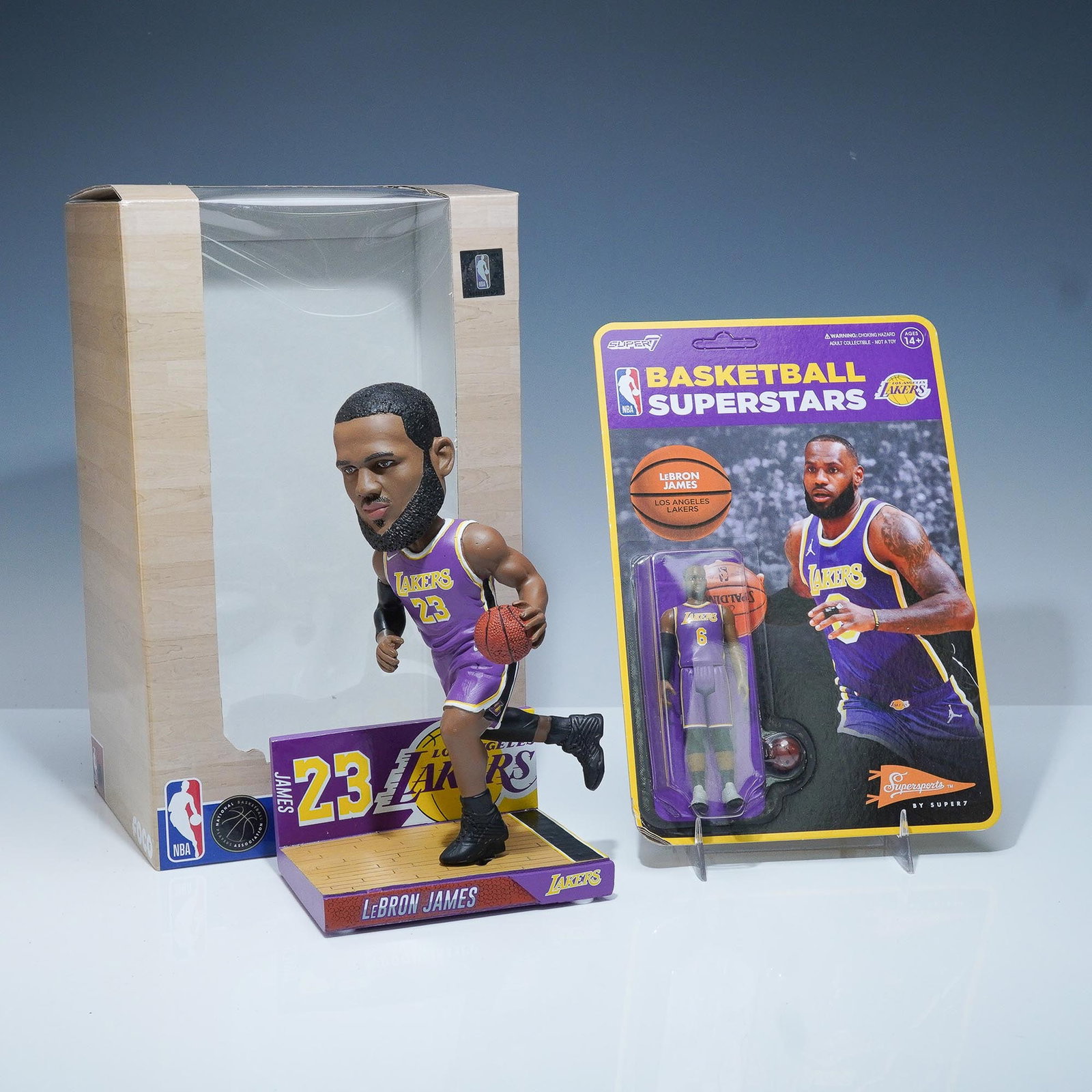 2pc LeBron James Lakers Collectibles, FOCO Bobblehead & Super7 Action Fig.: Two officially licensed LeBron James collectibles celebrating his time with the Los Angeles Lakers. Includes a limited edition FOCO Legends of "The Court" handcrafted bobblehead figure of LeBron James