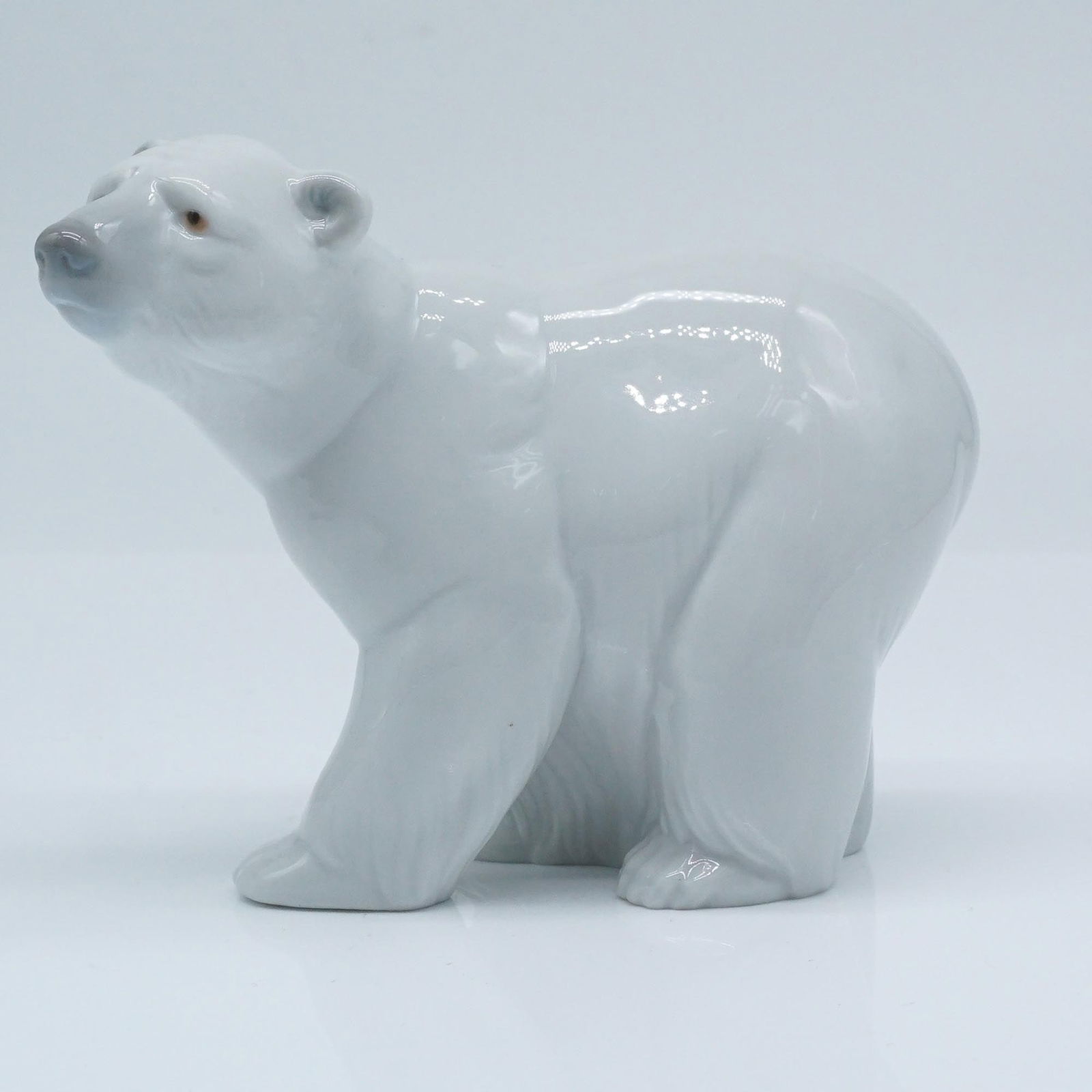 Lladro Porcelain Figurine, Attentive Polar Bear 1001207: This Lladro porcelain figurine, model number 1207, titled "Attentive Polar Bear" (Spanish name: Osito Atento Blanco), was sculpted by Juan Huerta. First issued in 1972 and retired in 2021, this piece