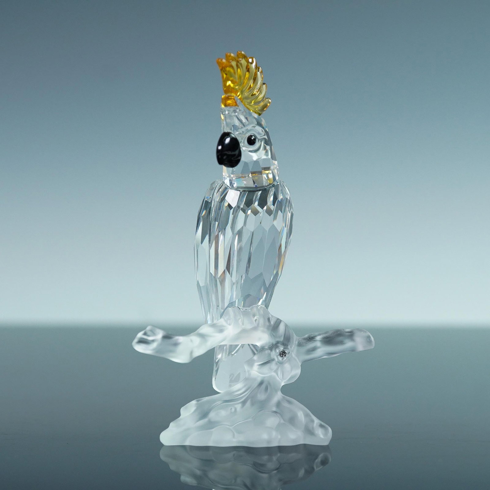 Swarovski Crystal Figurine, Cockatoo with Yellow Crest: This retired Swarovski Cockatoo figurine was introduced under the Feathered Friends collection, which later became known as Feathered Beauties. Featuring a faceted clear crystal body, black beak, and 
