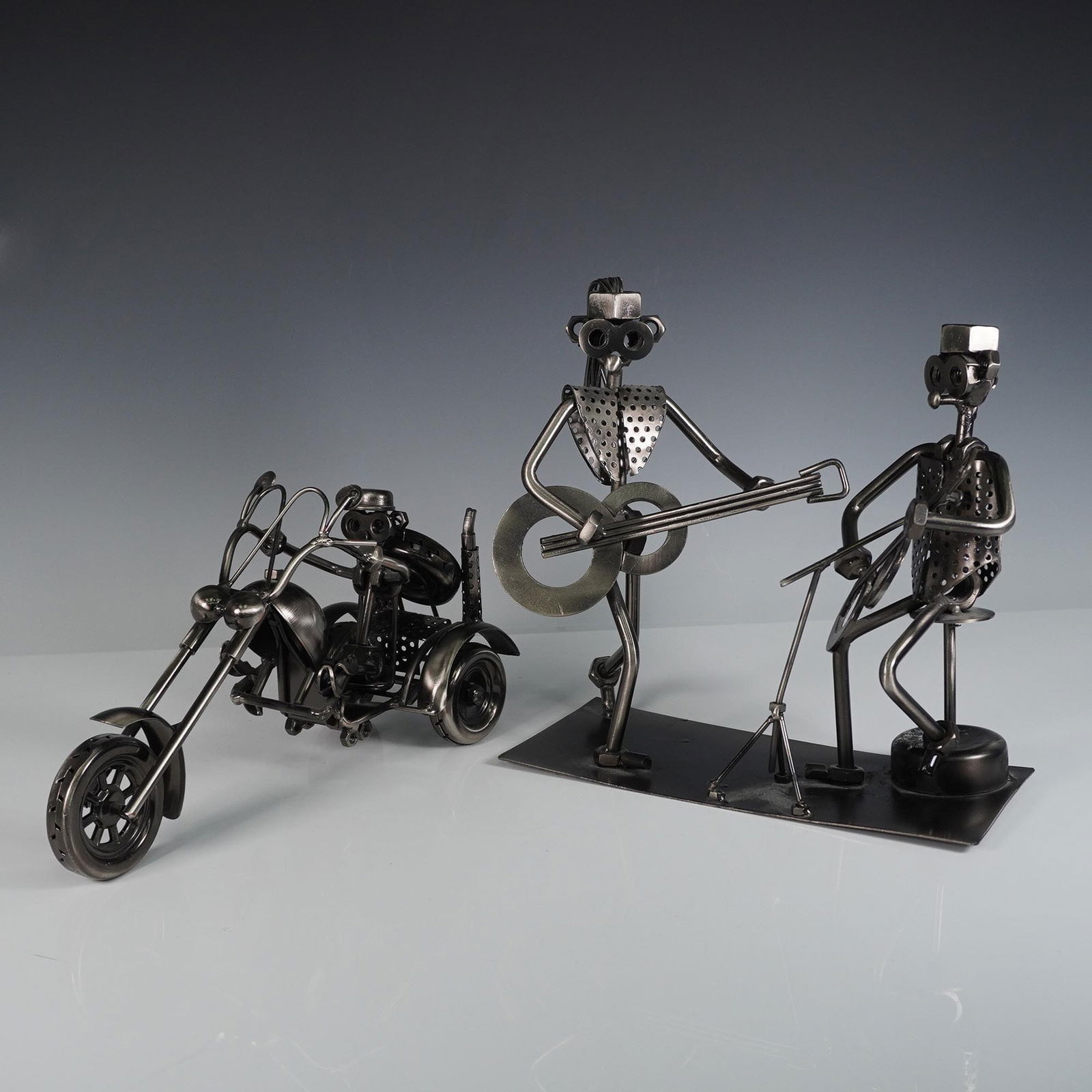 2pc Metal Sculpture Lot, Band Duo and Motorcycle Rider: Two-piece lot of welded metal sculptures featuring a stylized musician duo and a chopper motorcycle with rider. The band sculpture includes two abstract figures formed from nuts, bolts, and perforated