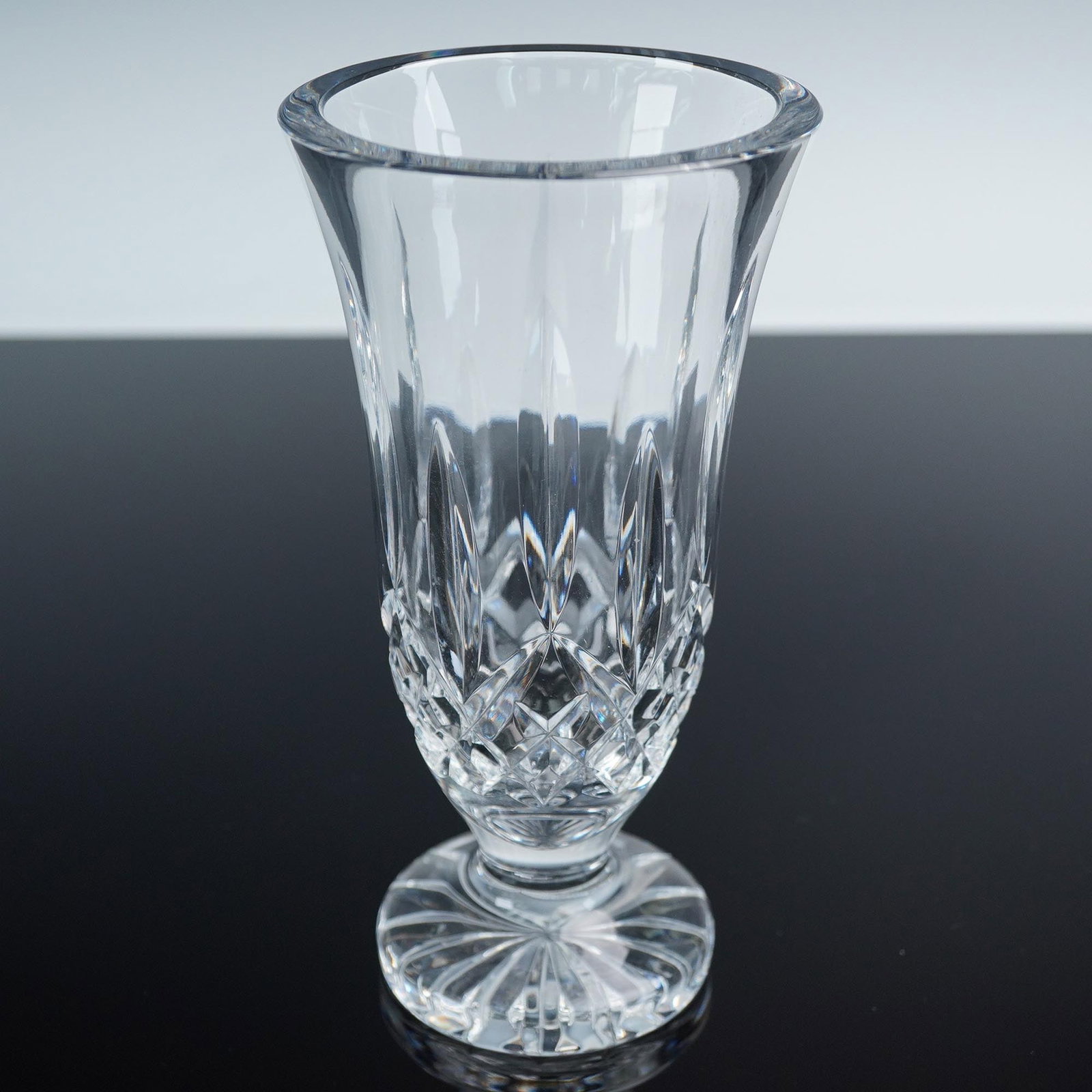 Waterford Crystal Lismore Flared Vase: Waterford crystal vase in the iconic Lismore pattern, featuring a flared rim with deep vertical and crosshatched cuts. Signed with the etched Waterford mark on the base. Issued: 20th century Dimension