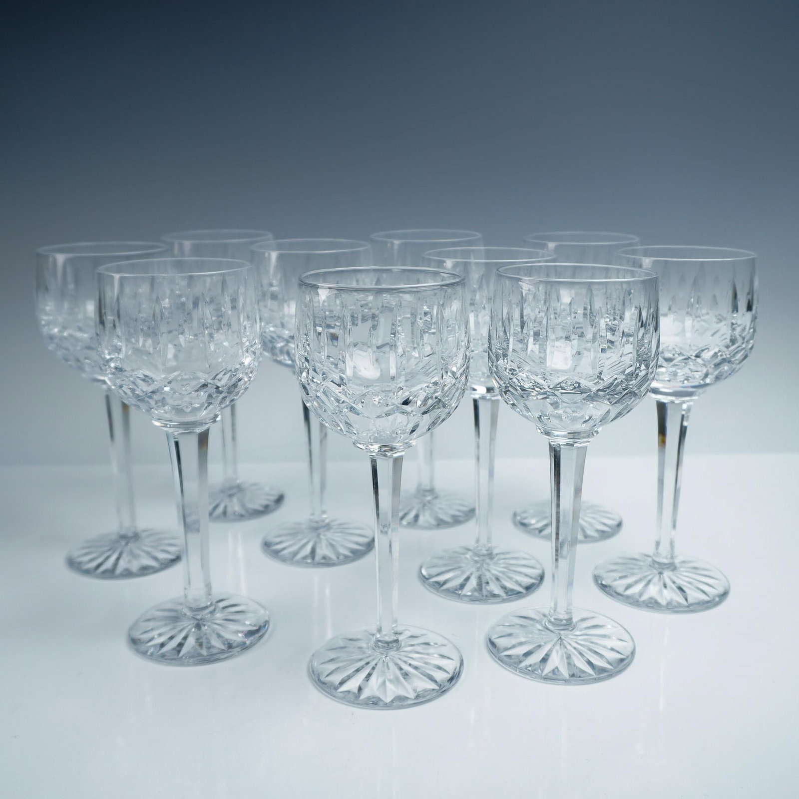 10pc Cut Crystal Wine Glasses, Star-Cut Base: Set of ten cut crystal wine glasses featuring deeply cut crisscross and vertical motifs, with classic starburst patterns across the foot and elegant, elongated stems. These glasses sparkle brilliantly