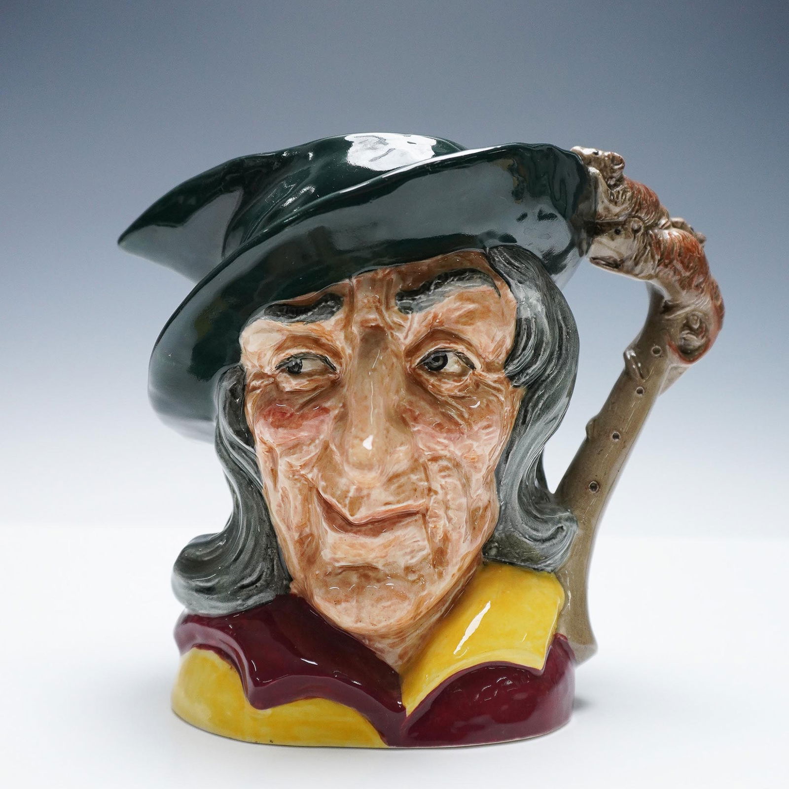 Royal Doulton Character Jug Pied Piper D6403: Royal Doulton large character jug titled Pied Piper, model D6403, designed by David B. Biggs and issued between 1953-1981. This expressive jug features the piper in a green cap with long flowing hair