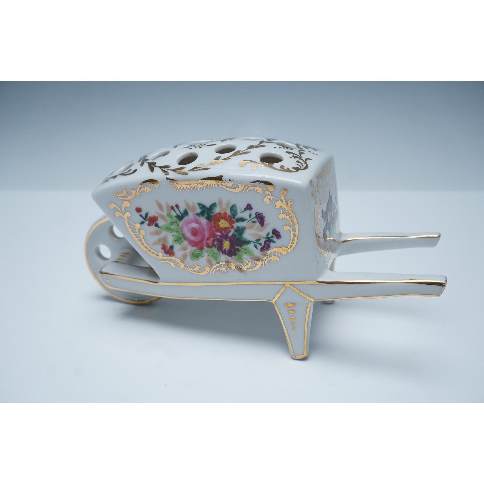 Shofu China Occupied Japan Porcelain Wheelbarrow Flower Frog: A delicate hand-painted porcelain wheelbarrow flower frog by Shofu China, marked "Made in Occupied Japan." This elegant piece features a white porcelain body adorned with intricate floral motifs and g