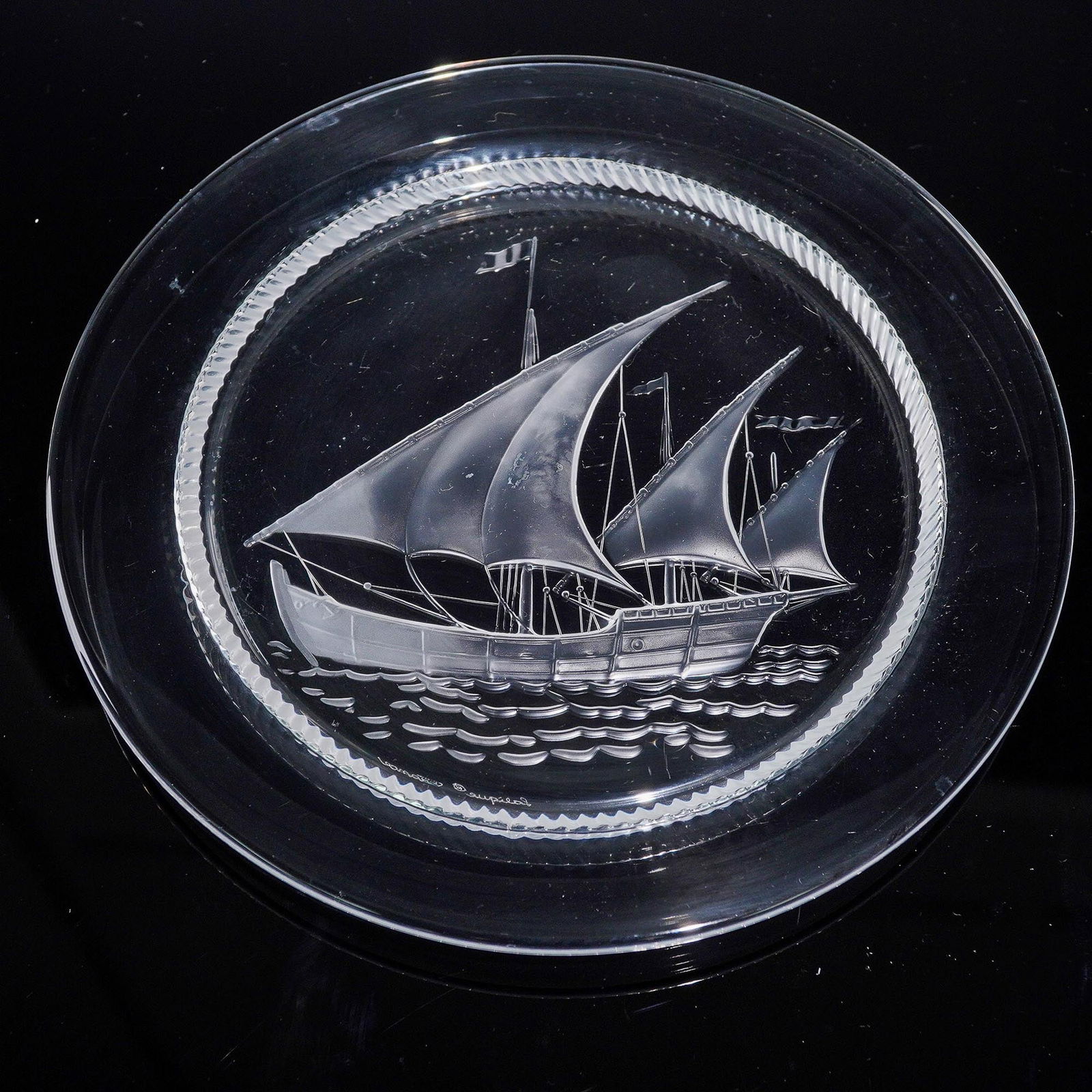 Lalique Crystal Plate, Ship Design: Elegant Lalique crystal plate featuring an intricately frosted and polished design of a sailboat with full sails and flags, rendered in exquisite relief. The plate's border is accented with a finely r