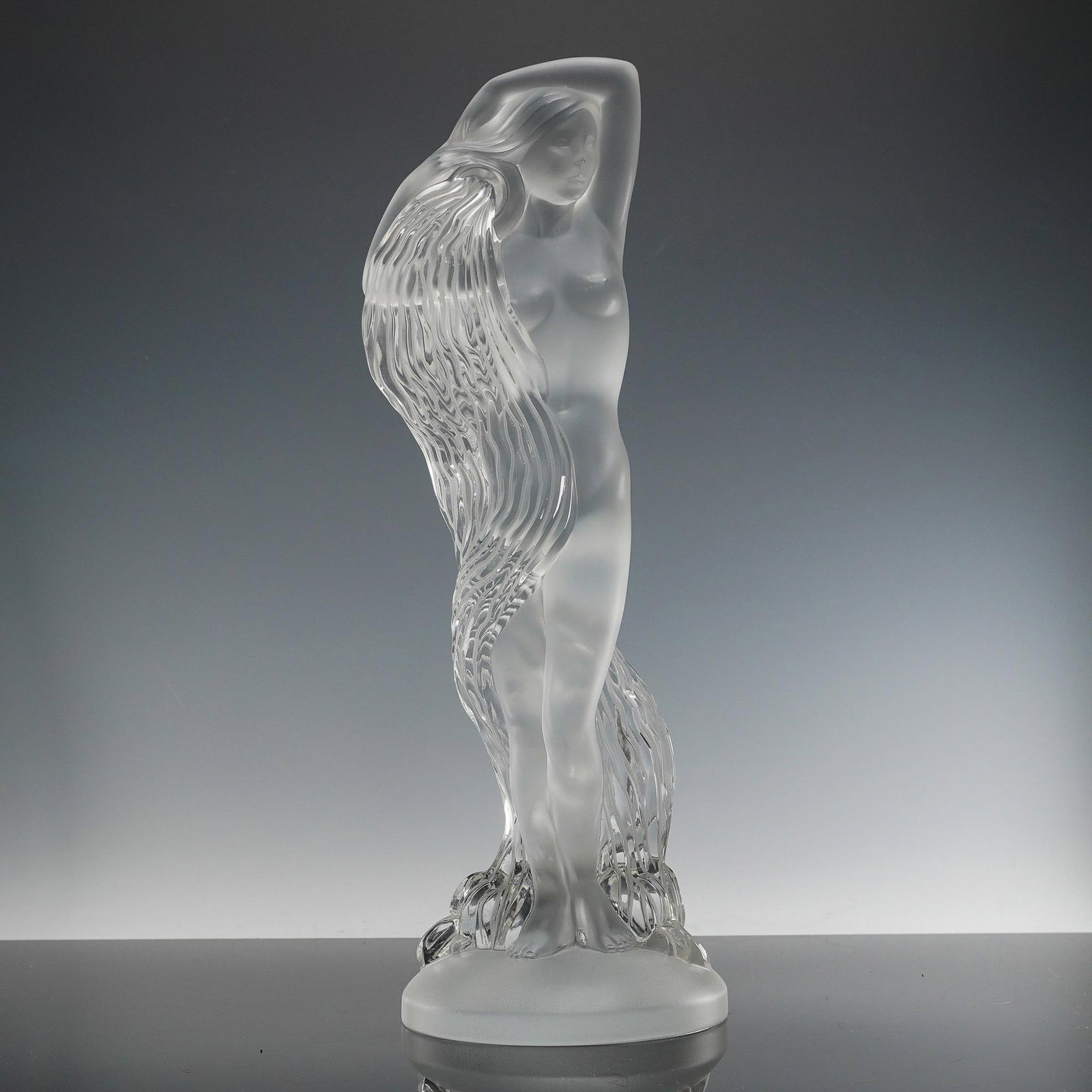 Lalique Crystal Statue, Grande Nue Nereides: A limited edition ethereal crystal sculpture featuring a standing nude female figure with arms lifted overhead, her form partially enveloped by cascading hair rendered in a striking contrast of froste
