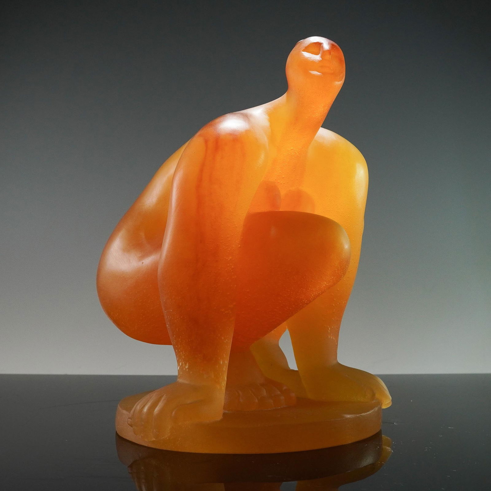 Daum by Catherine Lorain Glass Amber Sculpture, Nu Accroupi: Limited edition sculpture designed by Catherine Lorain (French, b. 1941) for Daum France. Formed in opaque amber pate de verre glass, the piece depicts a stylized nude figure in a crouching position,