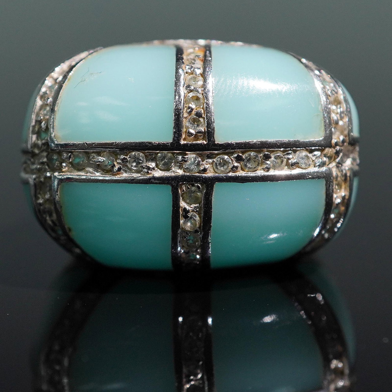 Sterling Silver and Turquoise-Colored Acrylic Ring with Crystal Accents: This sterling silver ring features a bold grid design with turquoise-colored acrylic inlays, accented by rows of sparkling clear crystals. The ring is marked 925 on the inner band, confirming its ster