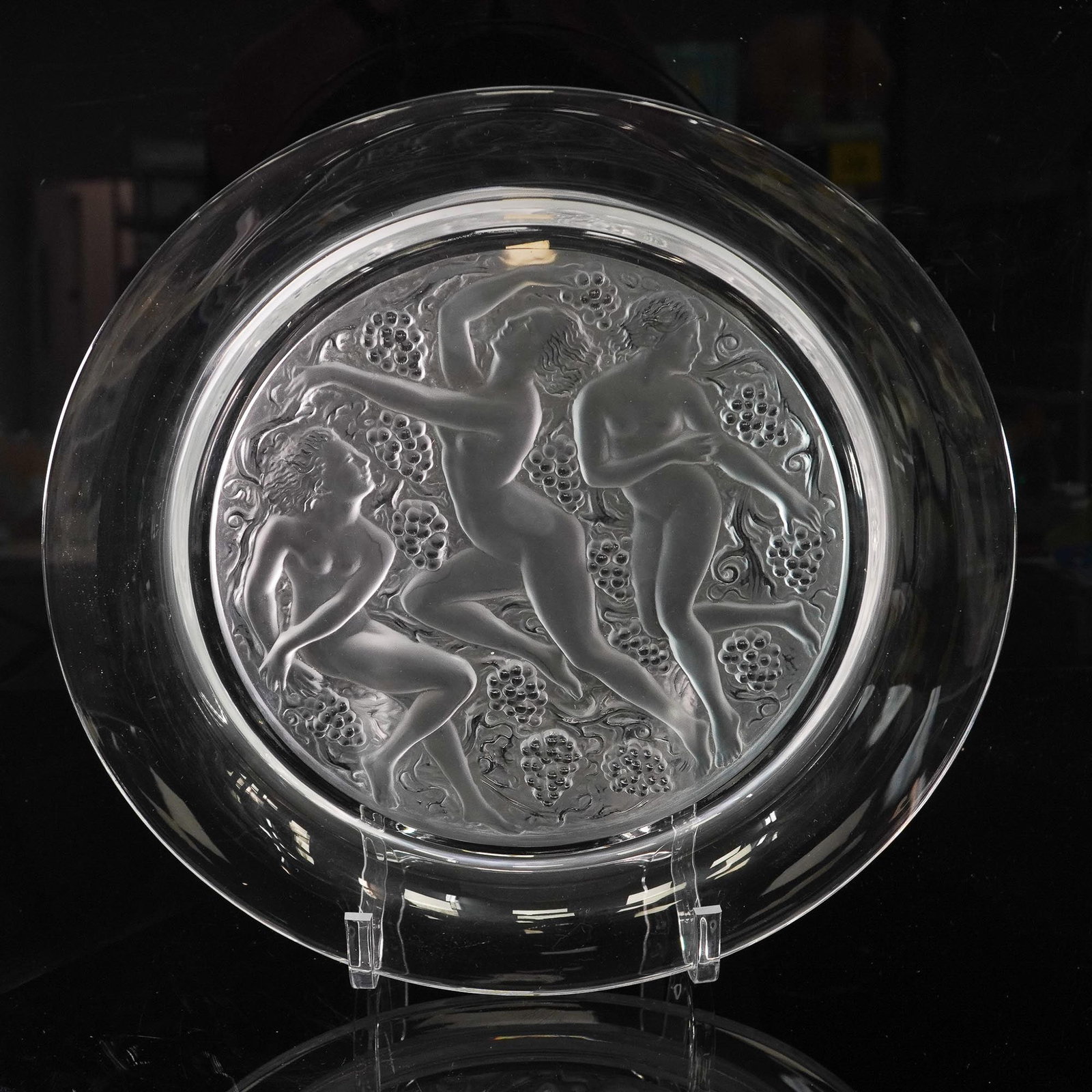 Lalique Crystal Plate, Cote D'Or: Clear and frosted crystal plate by Lalique, featuring a finely detailed central design of three nude female figures dancing among clusters of grapes and leaves in relief. The figures are rendered in L