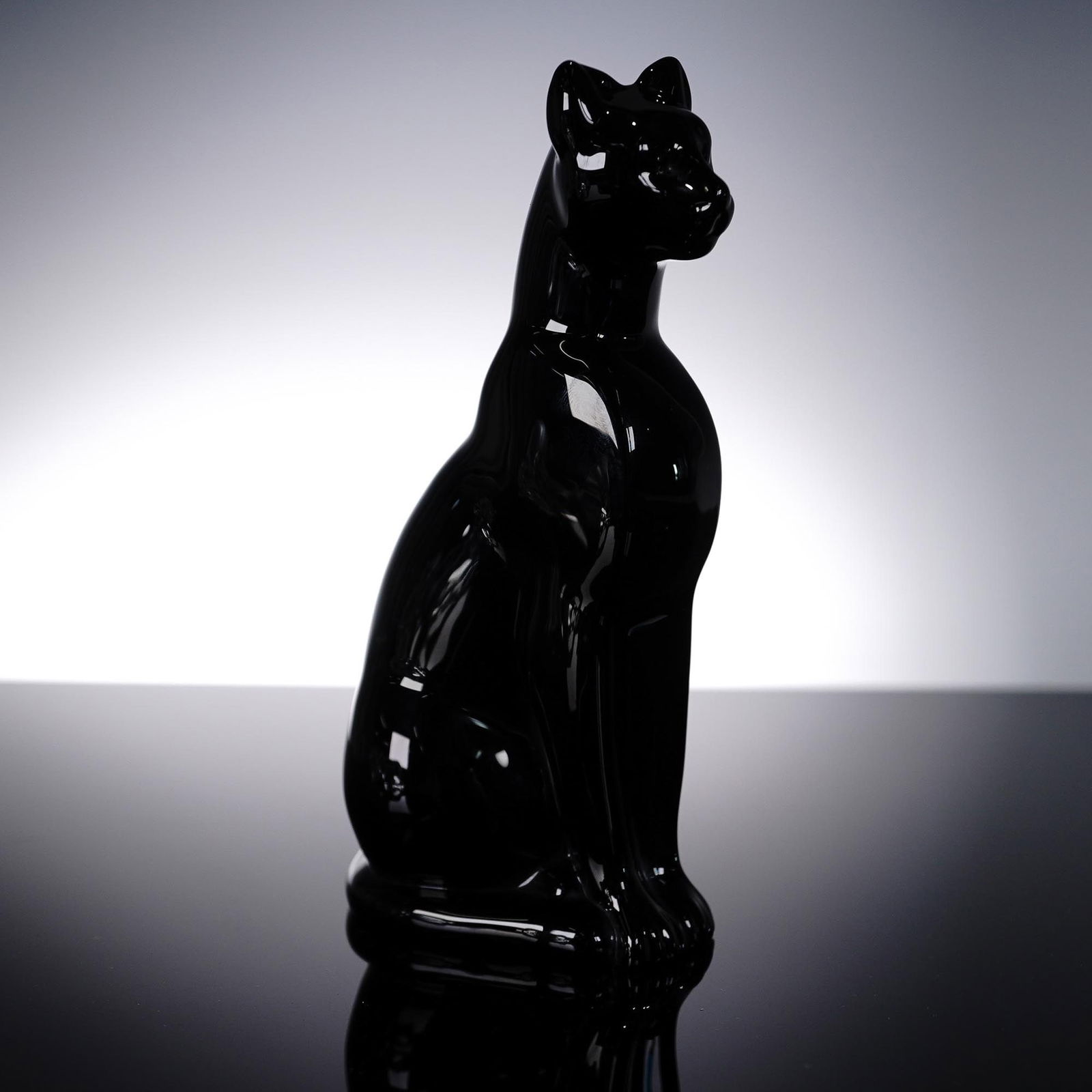 Baccarat Black Crystal Figurine, Egyptian Cat: Glossy black crystal figurine by Baccarat, masterfully shaped into a regal Egyptian-style seated cat. This sleek and elegant piece features refined contours and a polished finish, evoking the divine s