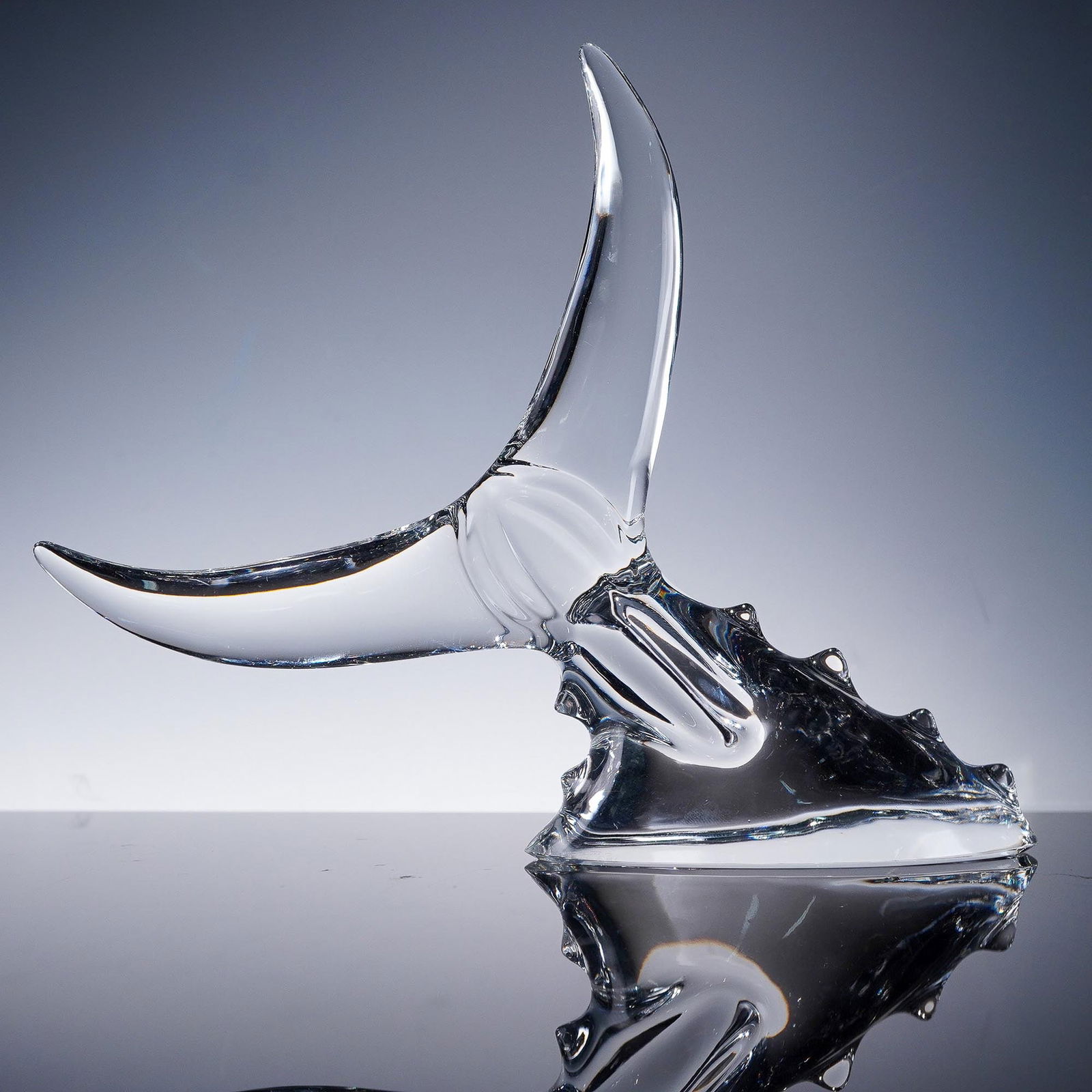 Baccarat Crystal Tuna Tail Paperweight: This dynamic Baccarat crystal paperweight captures the elegant motion of a whale's tail as it crests the surface of the sea. Expertly sculpted from clear crystal, the design features sweeping curves a