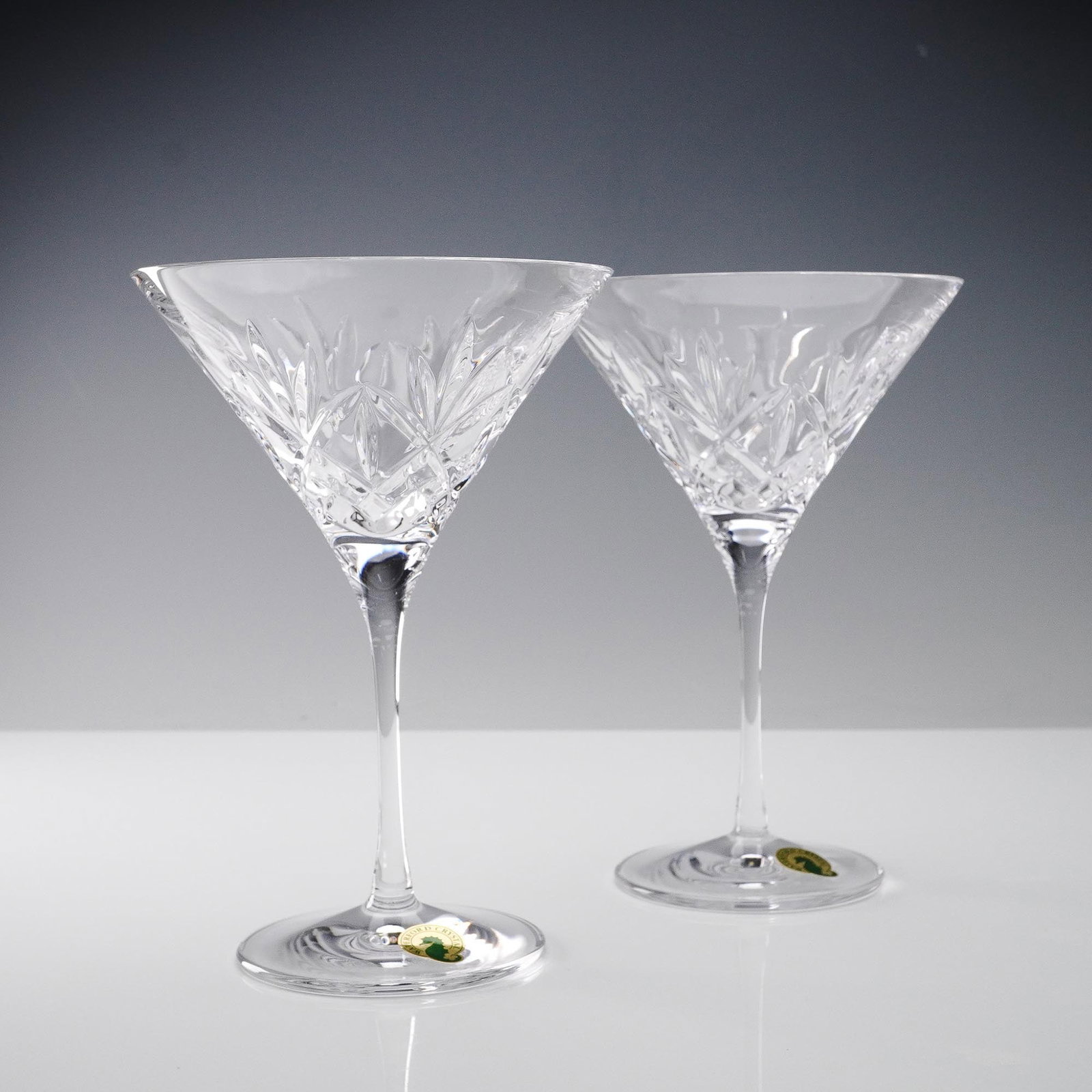 Waterford Crystal Martini Glasses Pair: A pair of Waterford crystal martini glasses featuring classic deep wedge cuts in brilliant lead crystal. These glasses showcase the iconic Waterford craftsmanship, with precision-cut designs that refl