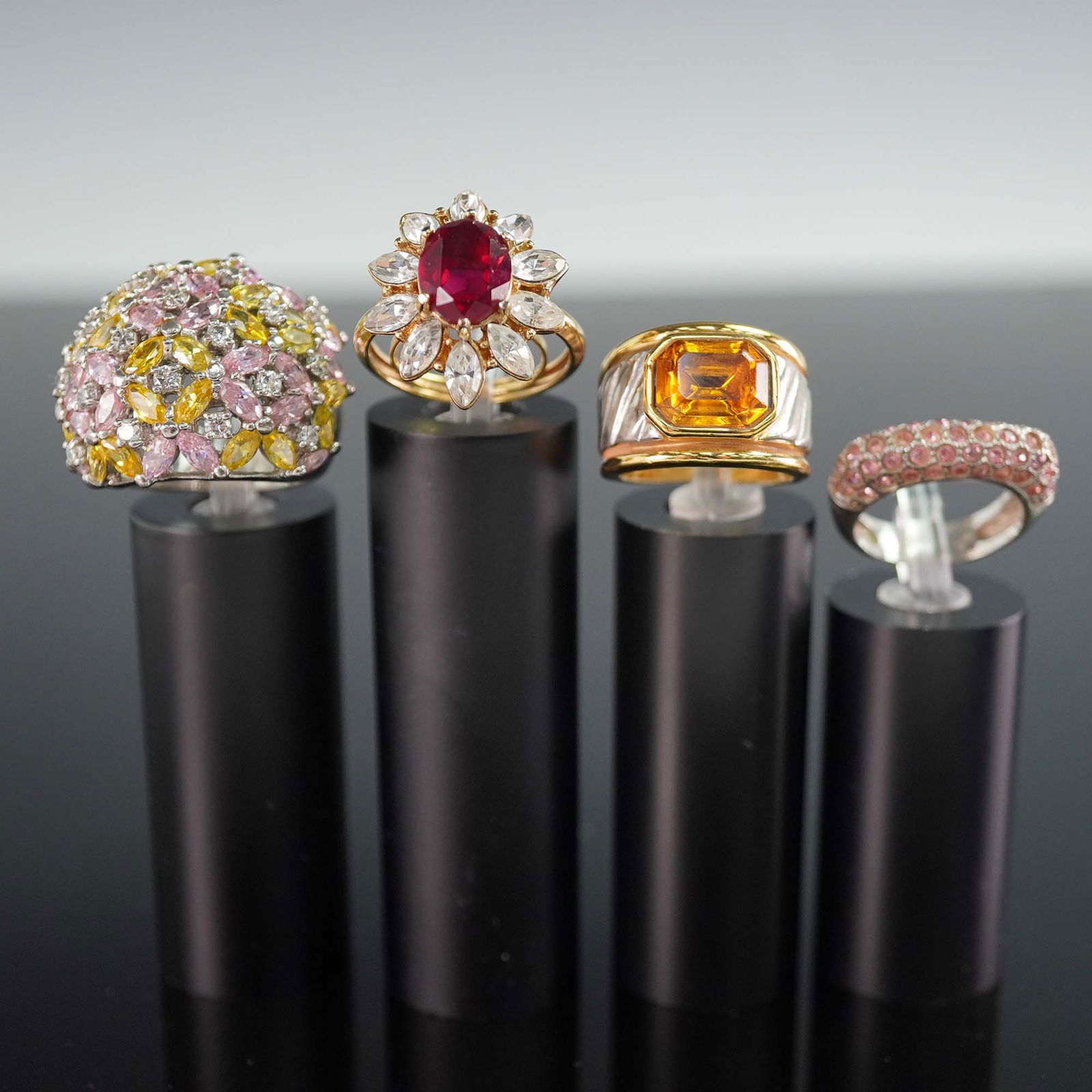 4pc Statement Cocktail Rings with Mixed Stone Settings: A dazzling set of four statement cocktail rings featuring a mix of vintage and contemporary designs with bold stones and dramatic settings. This group includes a domed pave ring set with rows of pink