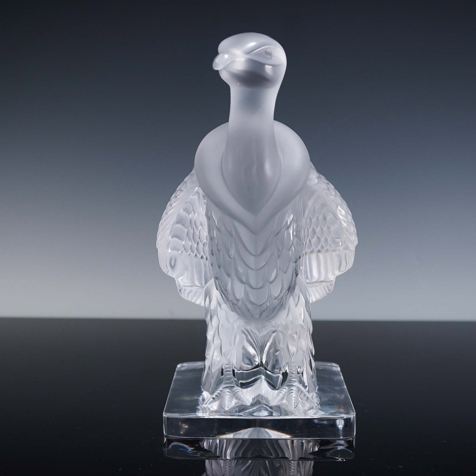 Lalique Crystal Sculpture, Vulture Condor: Crafted in clear and frosted crystal. The sculpture features a stylized vulture or condor standing upright on a square plinth base, its head turned slightly to the side. The surface combines satin and