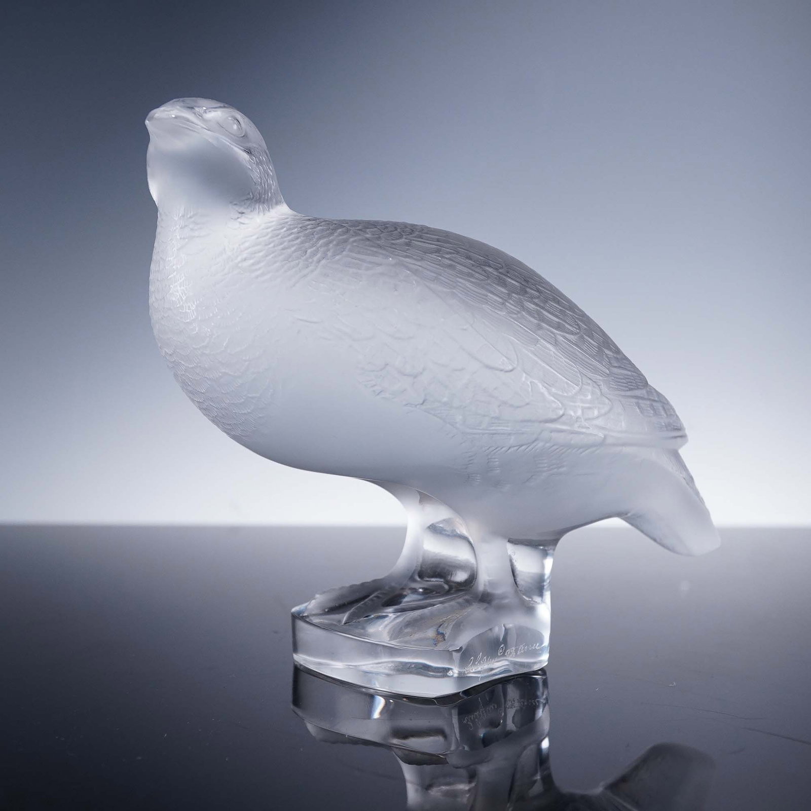 Lalique Crystal Figurine, Partridge: A crystal partridge figure, rendered in frosted and clear crystal with meticulously textured plumage and an uplifted head. This elegant design showcases the bird in a poised, alert stance, enhancing i