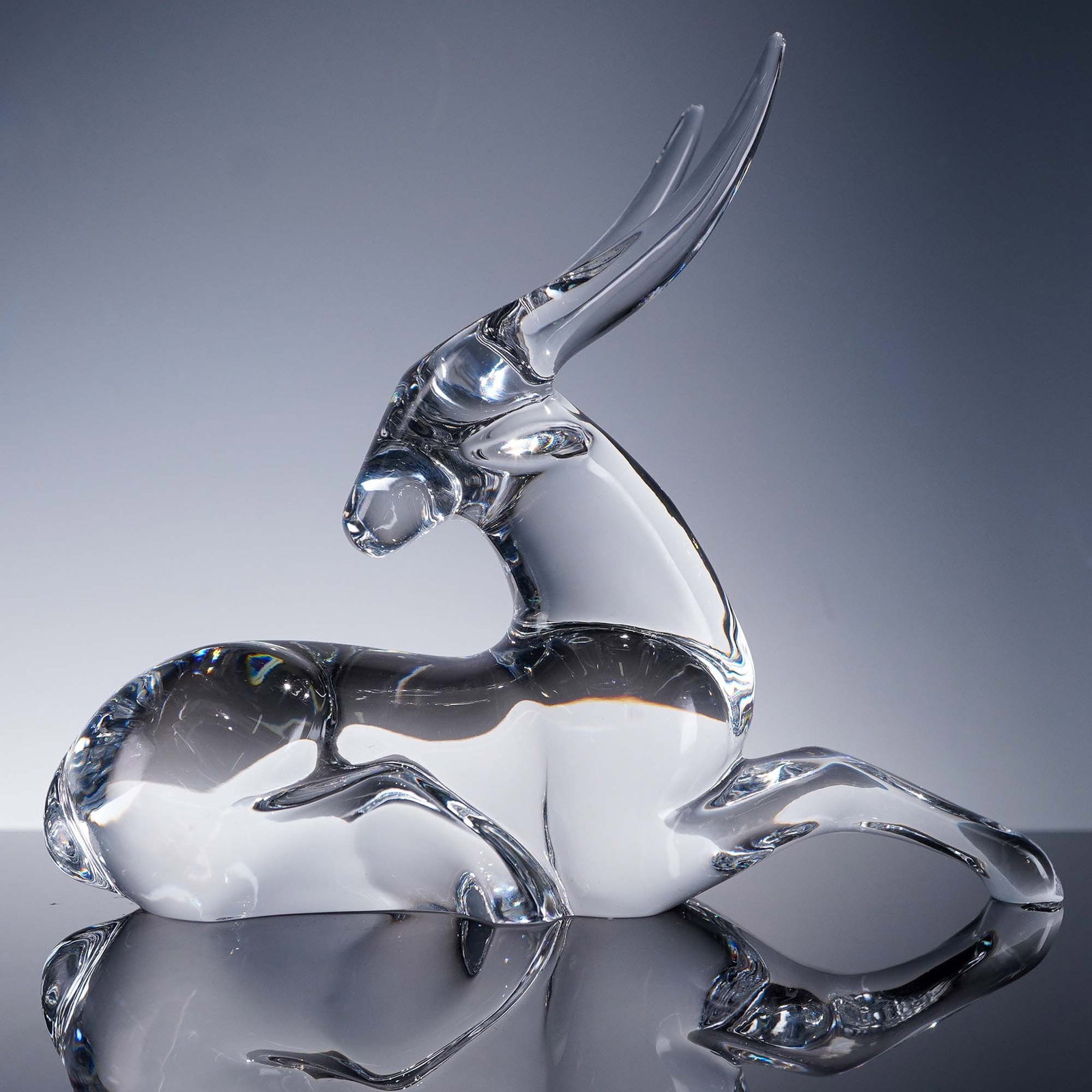 Baccarat Crystal Figurine, Resting Antelope by Loet Vanderveen: Clear crystal antelope sculpture designed by Loet Vanderveen for Baccarat, capturing the sleek elegance of the animal in a stylized resting pose. This refined piece bears the etched Baccarat hallmark 