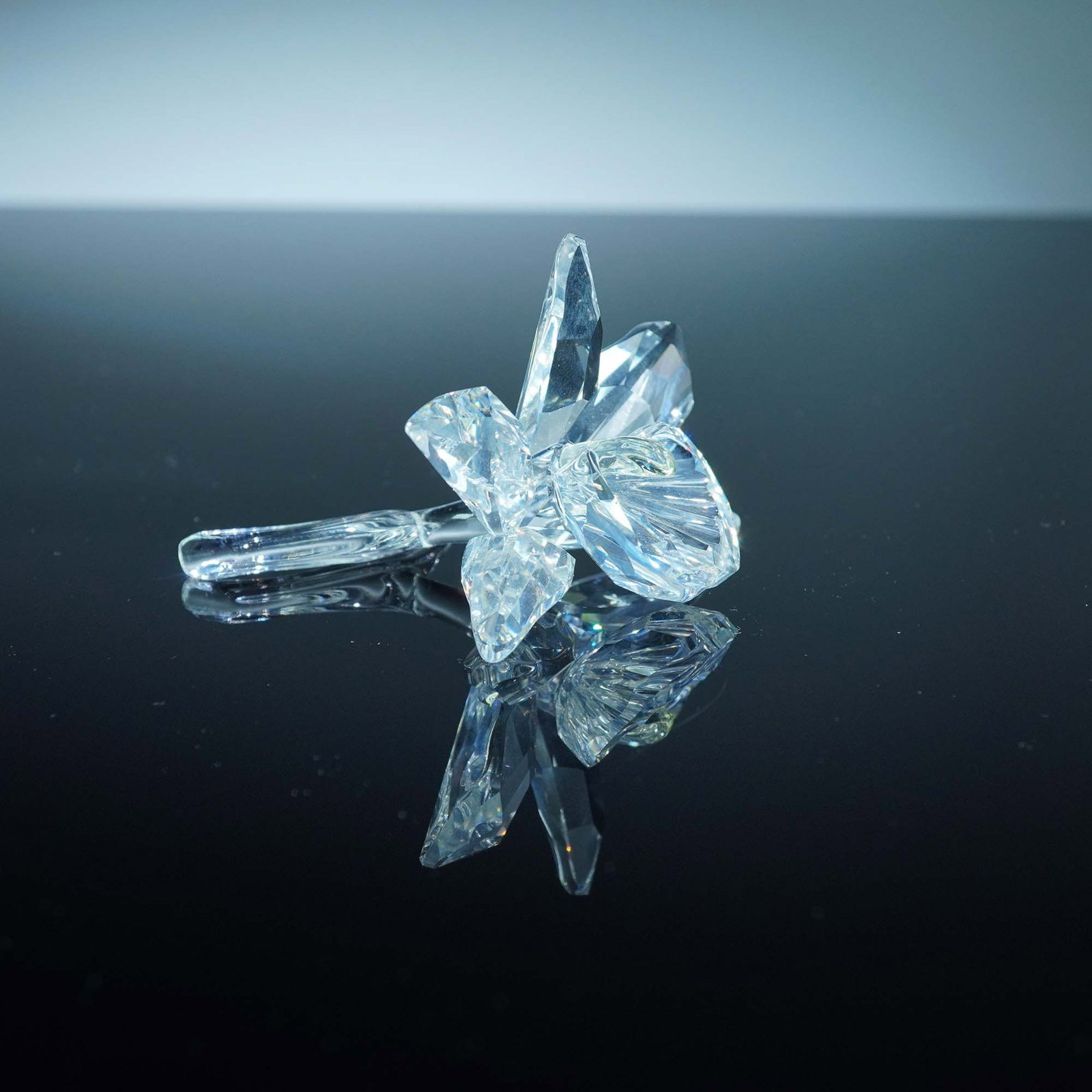 Swarovski Crystal Figurine, Orchid - Yellow Light Center: From the "Exquisite Accents" theme group. The piece features clear crystal petals and a clear stem. At the center is a light yellow crystal accent representing the flower's core. The figurine is marke
