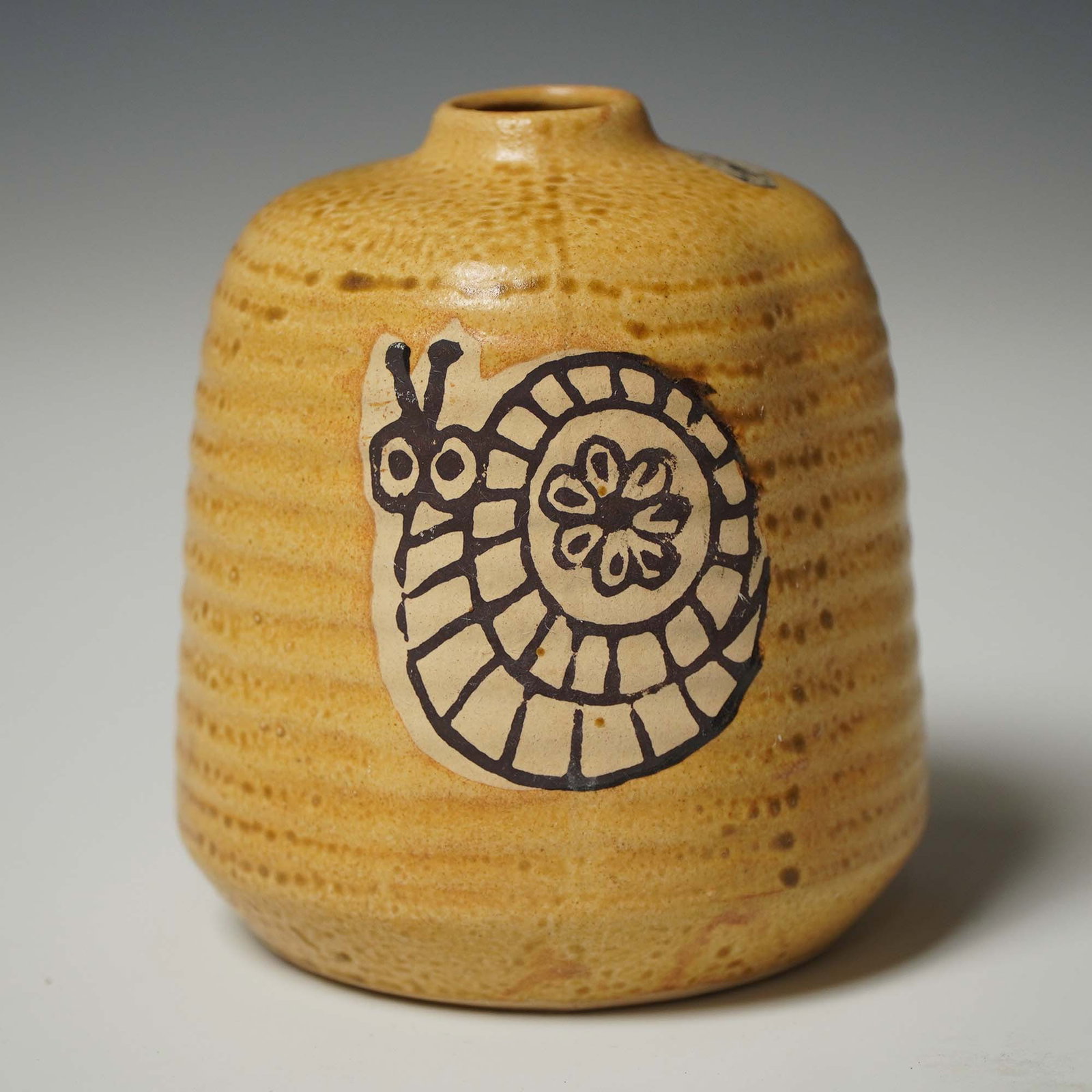 Nikko Stoneware Vase with Snail Design, 4.75"H: Charming mid-century stoneware vase marked "Nikko" Genuine Stoneware from Japan, distributed by Westwood, San Francisco. Features a warm ochre glaze with textured ridges and a stylized black snail mot