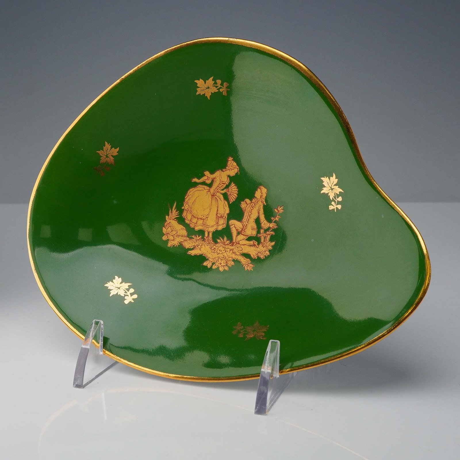 Limoges France Green Porcelain Dish with Gilt Courting Scene: This decorative porcelain dish from Limoges, France features a rich emerald green ground adorned with a gilt Rococo-style courting couple at the center, surrounded by scattered gold floral sprigs. Mar