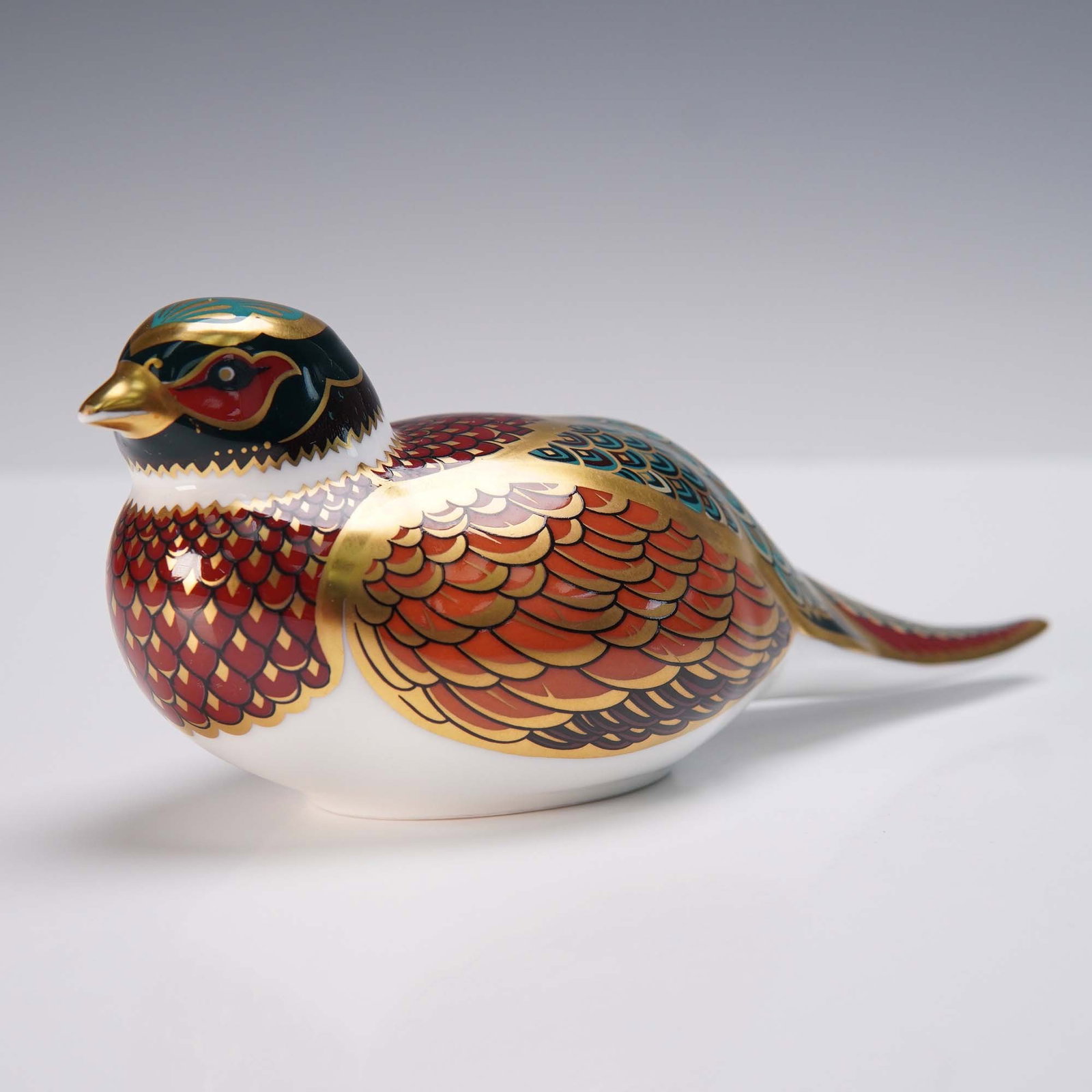 Royal Crown Derby Woodland Pheasant Paperweight, 1998 Collector's Guild: Royal Crown Derby English bone china paperweight in the form of a Woodland Pheasant, exclusively produced in 1998 for the Royal Crown Derby Collector's Guild. Handpainted in rich rust, cobalt blue, an