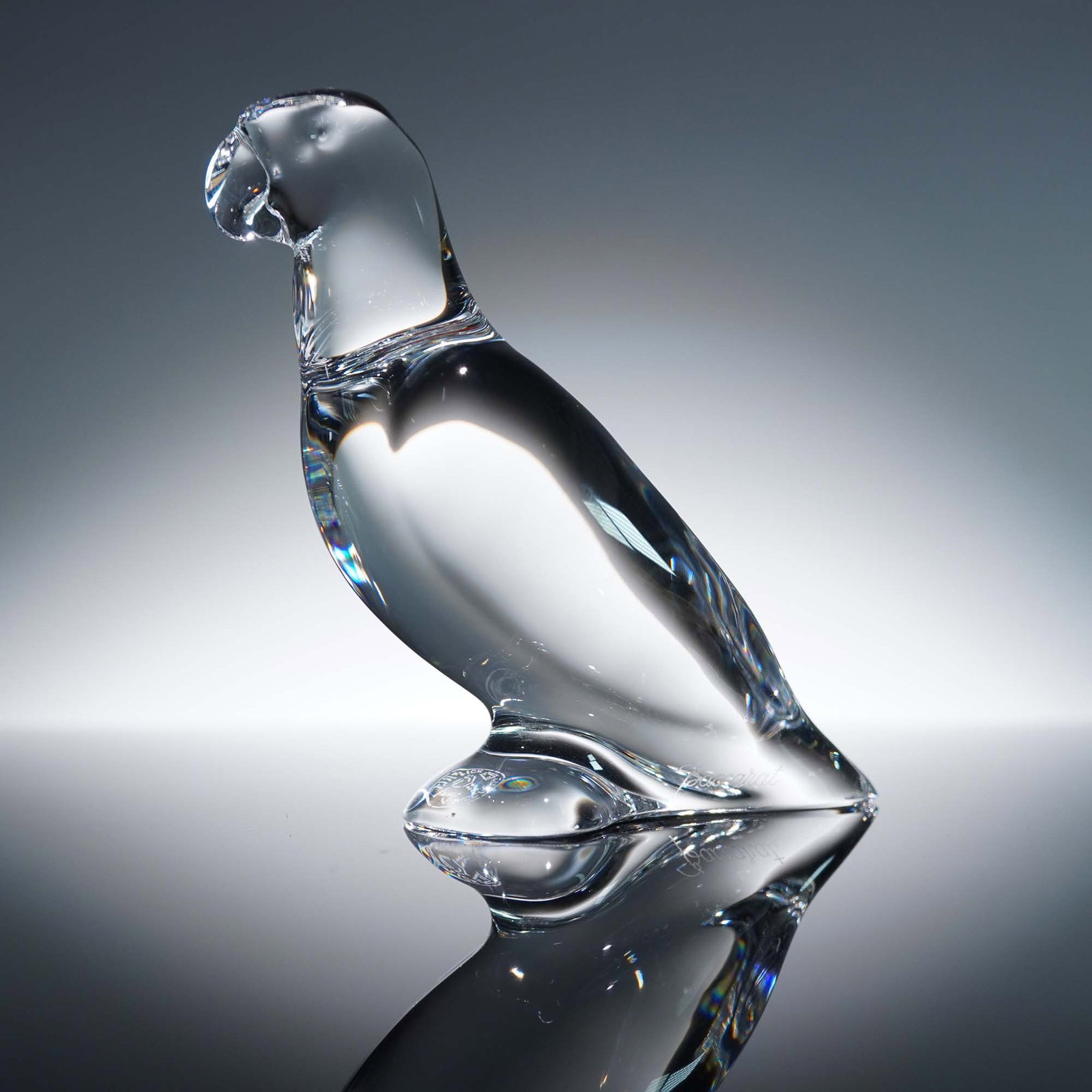 Baccarat Crystal Figurine, Parrot: Elegant Baccarat crystal figurine depicting a parrot with a sleek, polished finish that captures the majestic posture of this exotic bird. The smooth contours and balanced form reflect the refined art