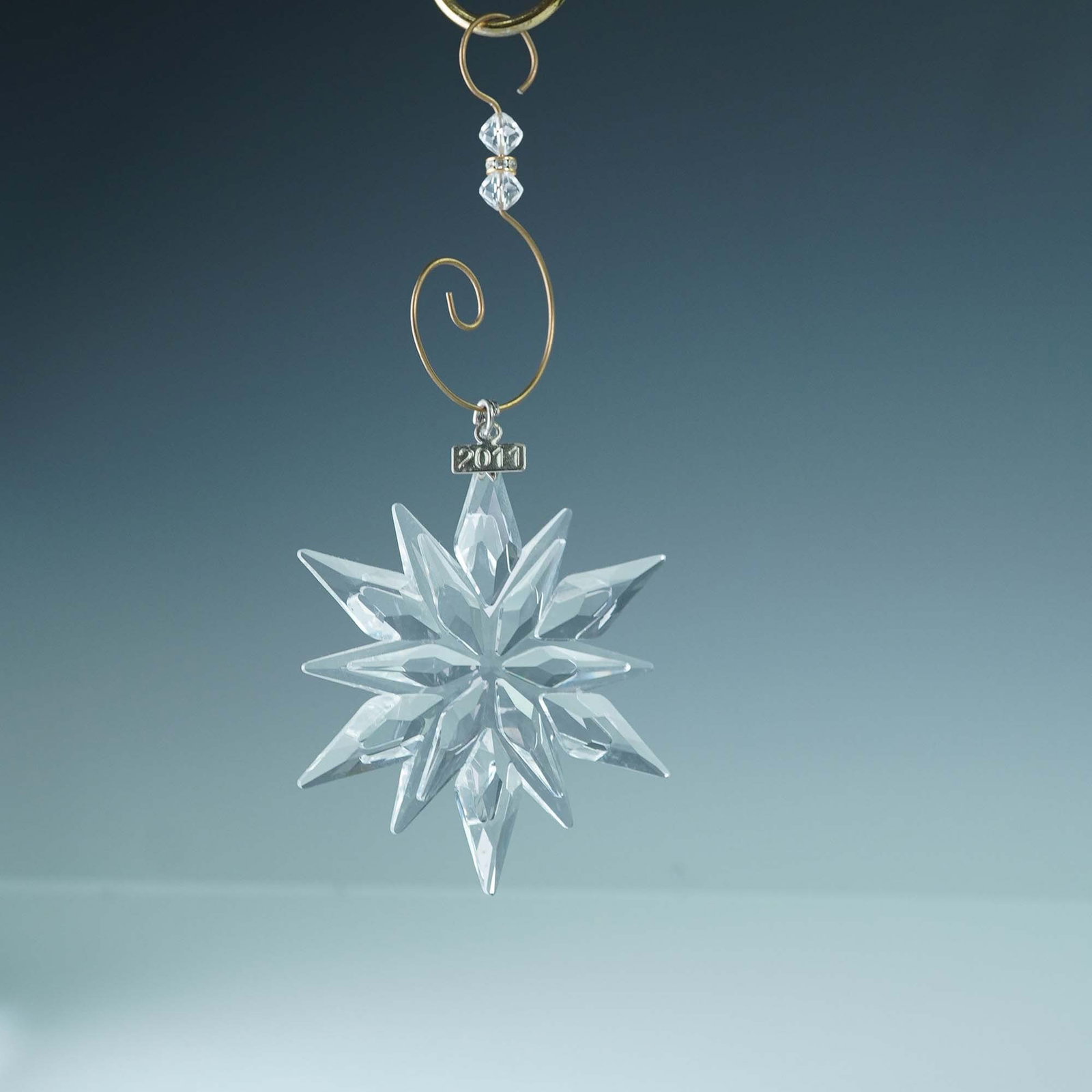 Swarovski Crystal 2011 Christmas Ornament: This retired Swarovski 2011 Annual Edition Christmas Ornament features a radiant 12 point faceted clear crystal star and a 2011 etched metal tag. The original ribbon is not included. A Swarovski Chris