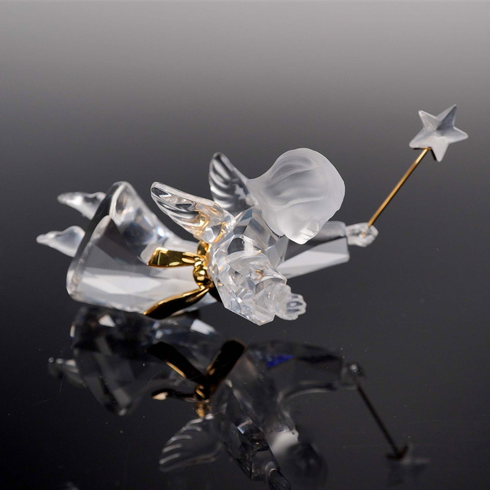 Swarovski Crystal Angel Ornament: This Swarovski crystal angel ornament features a graceful, faceted design with frosted wings, a golden ribbon, and a delicate wand tipped with a clear crystal star. The figurine captures the elegance 