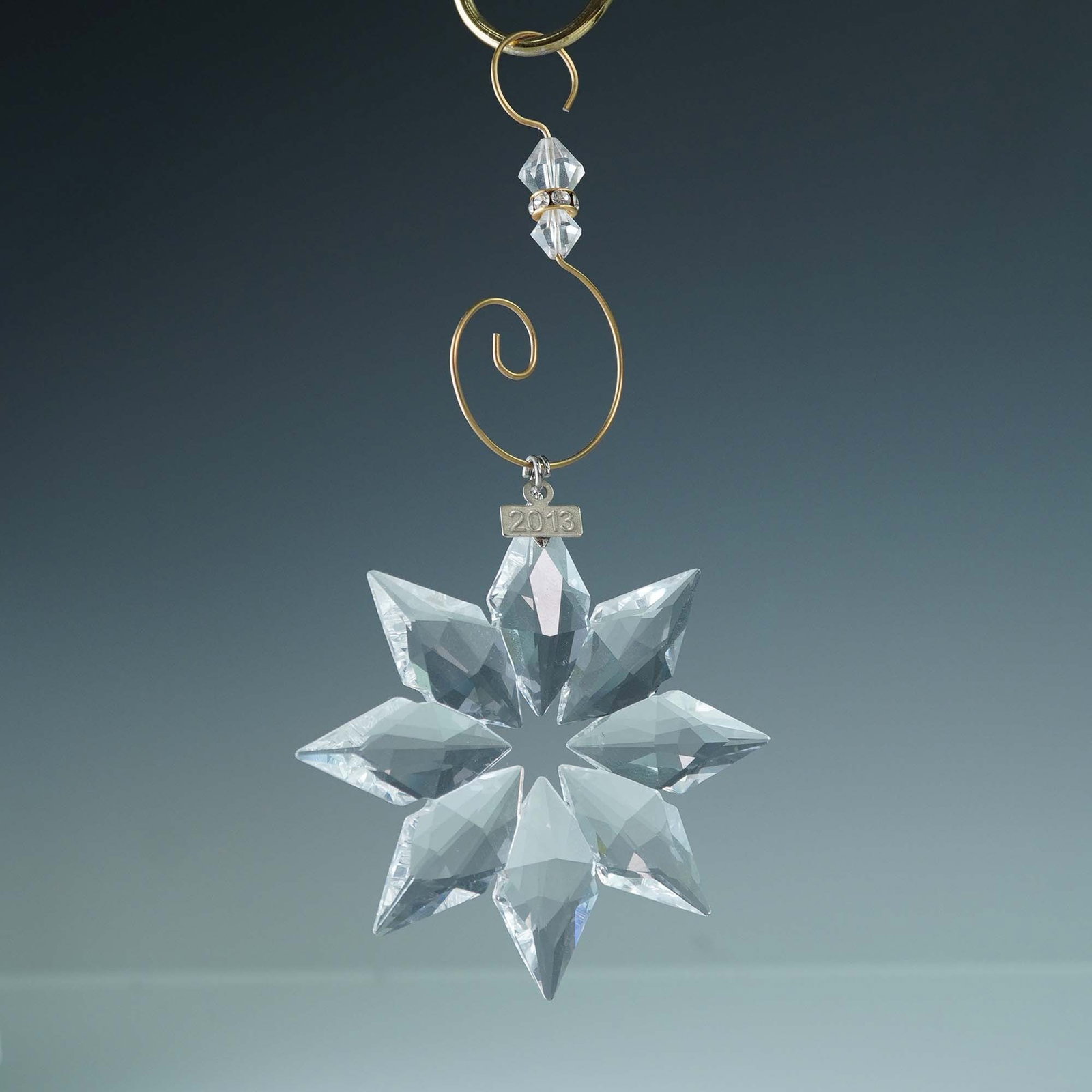 Swarovski Crystal Ornament, 2013 Christmas Star 5004489: Swarovski Annual Edition Christmas ornament from 2013, designed by Elisabeth Adamer. The elegant star-shaped ornament features clear crystal facets that beautifully reflect the light. Hung by an ornam