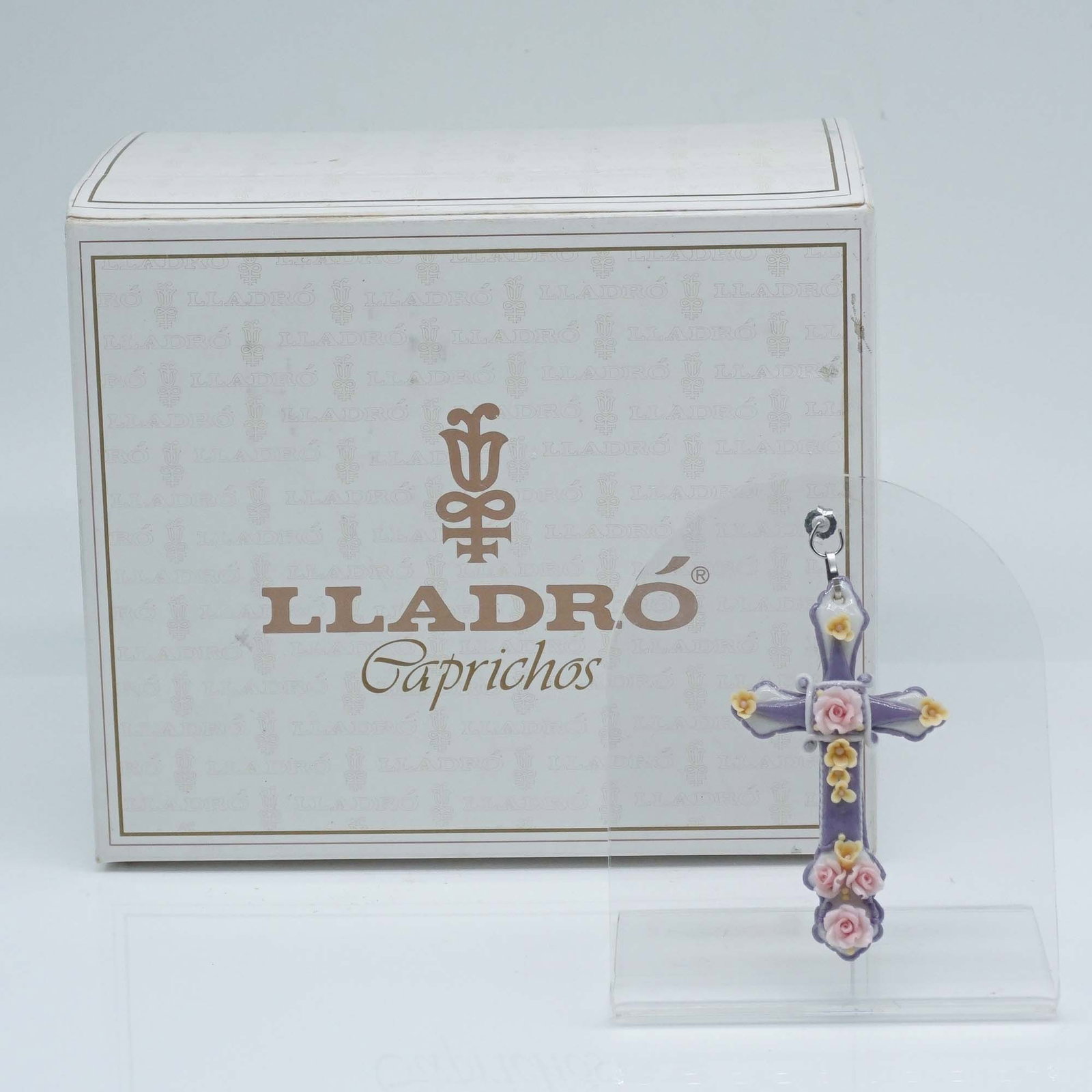 Lladro Porcelain Pendant, Medieval Cross 01001652: Lladro porcelain pendant #01001652, Medieval Cross #4, crafted in a richly detailed design with vibrant pastel flowers and intricate hand-applied accents. This piece captures the timeless elegance of 