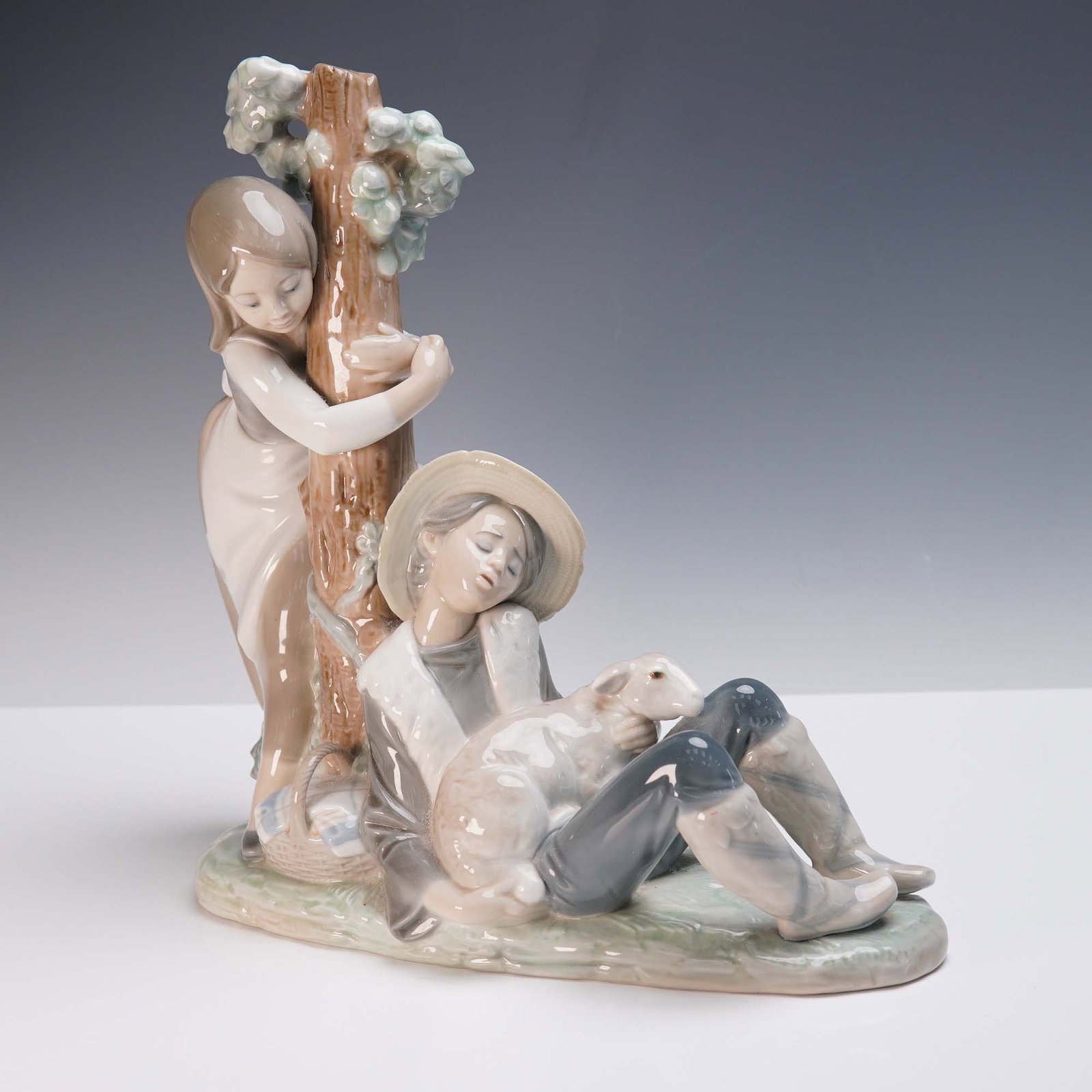 Lladro Porcelain Figurine, Caught Napping 1256: Crafted by Lladro and designed by sculptor Juan Huerta, this charming porcelain figurine titled Caught Napping captures a tranquil pastoral scene of a young shepherd resting with a lamb nestled in his
