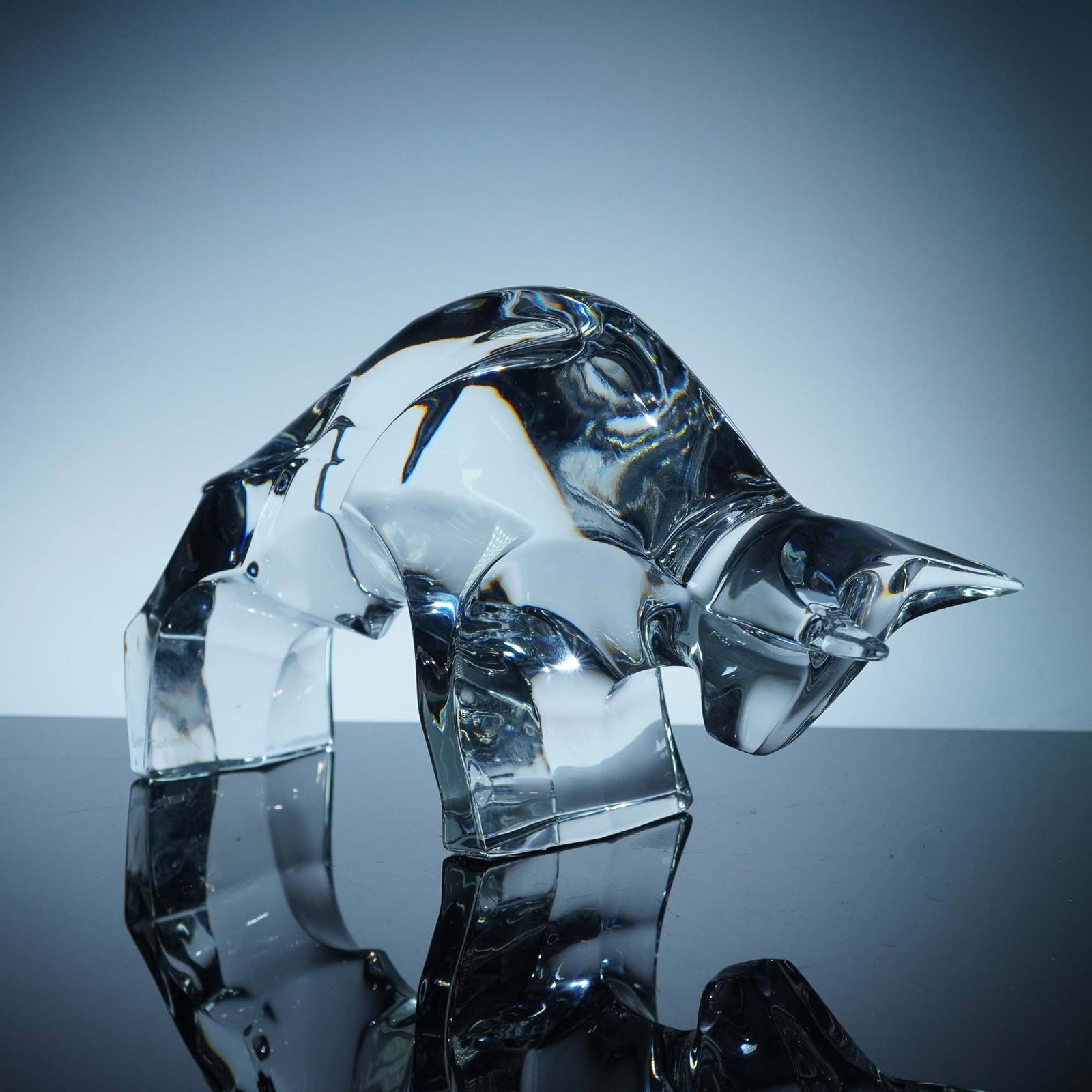 Baccarat Crystal Figurine, Bull: A clear crystal bull figurine sculpted with a striking minimalist angularity and dramatic form. The powerful stance and sharp contours capture the animal's strength and presence. Baccarat backstamp. I